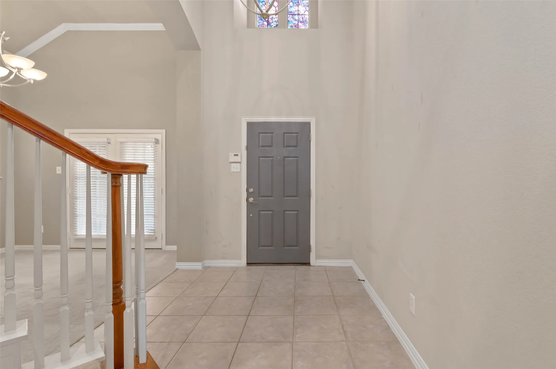 Entry with stained glass window, dining room flex space to the left.
