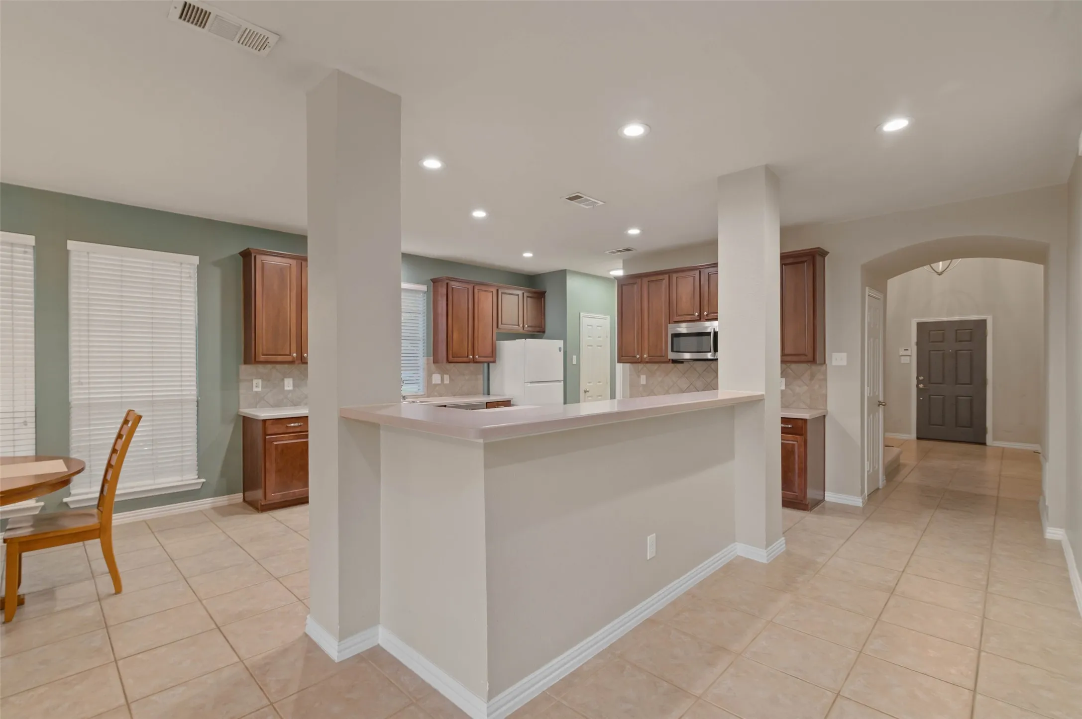 Open floor plan kitchen with breakfast area, breakfast bar and view of the entry.