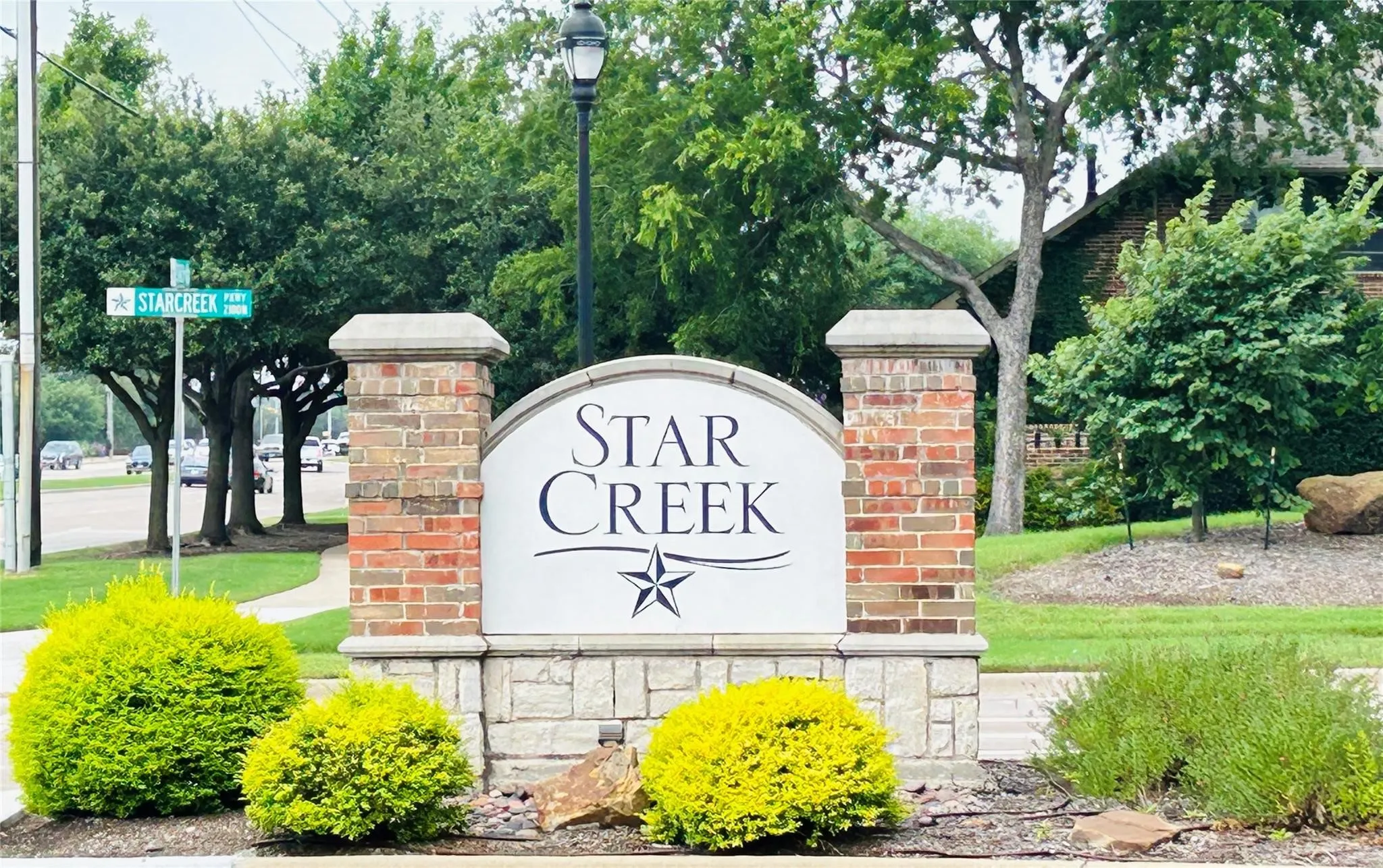 Star Creek community entrance featuring a brick and stone monument with integrated signage