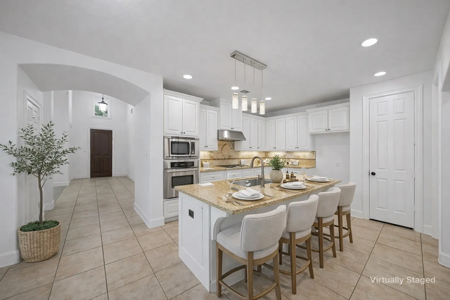 Expansive kitchen featuring white cabinetry, stainless steel appliances, granite countertops, and a large island with seating
