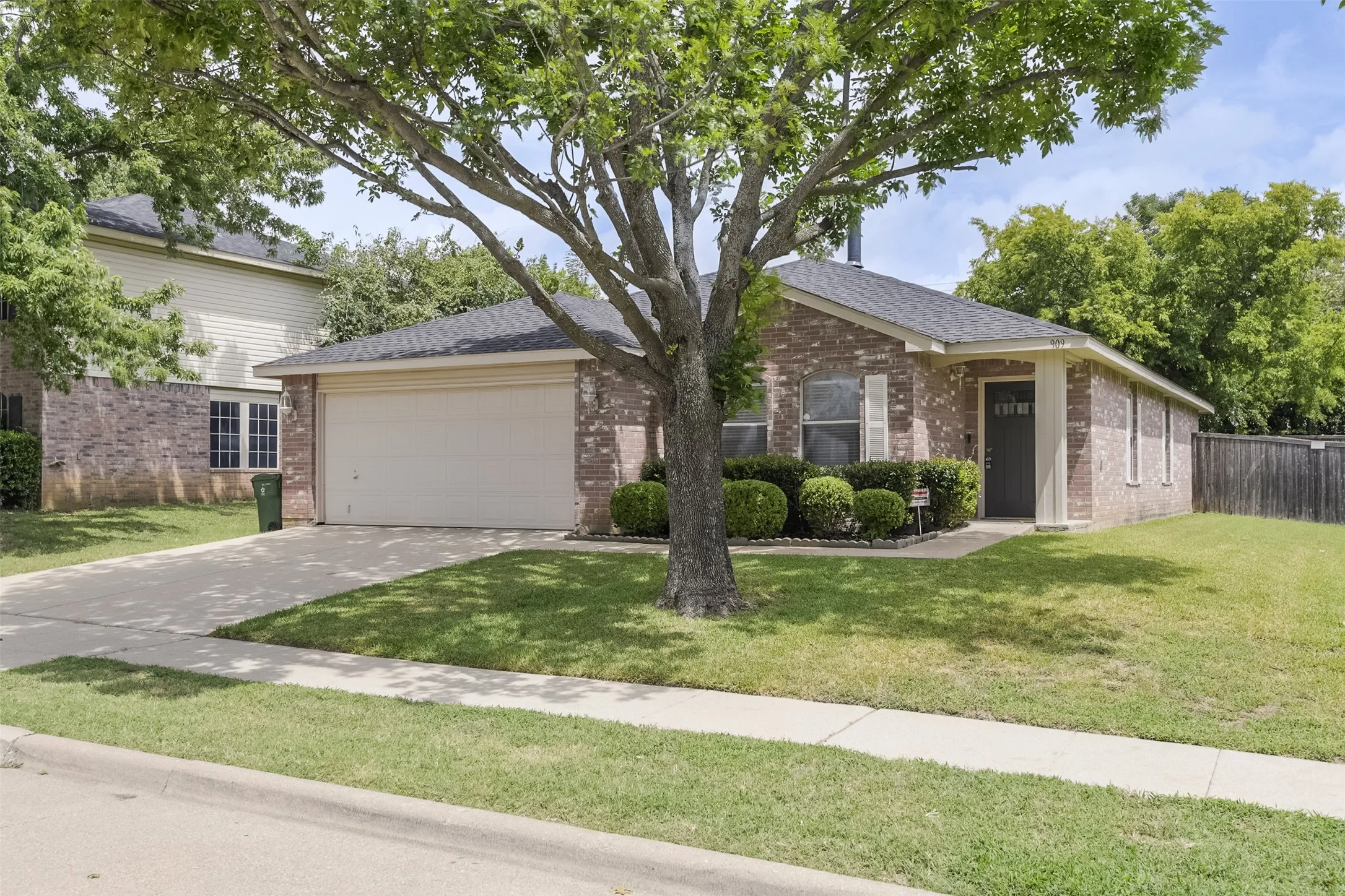 Expansive backyard featuring a covered patio, wood privacy fencing, and mature perimeter trees