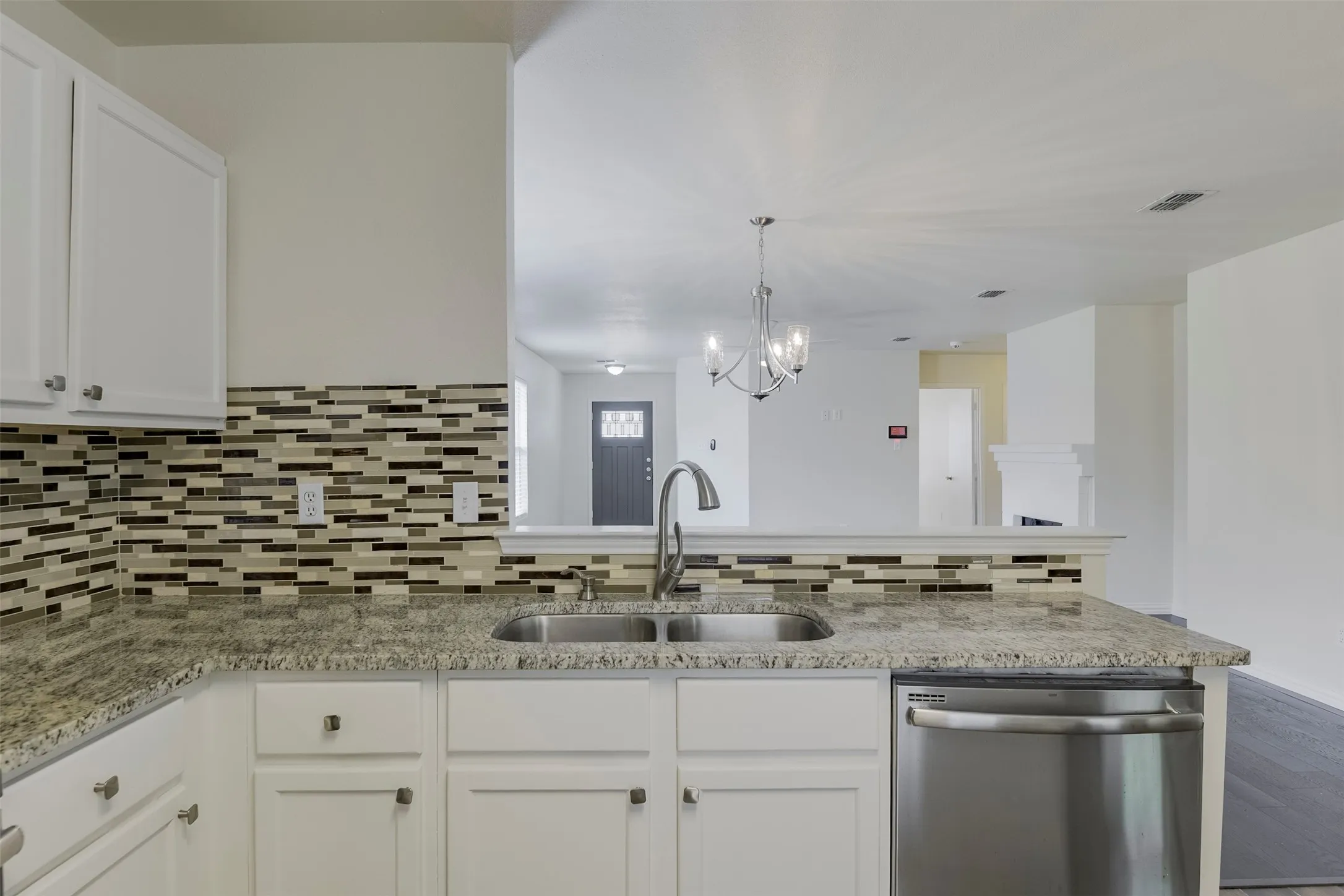 Kitchen has view of living room and stainless appliances.