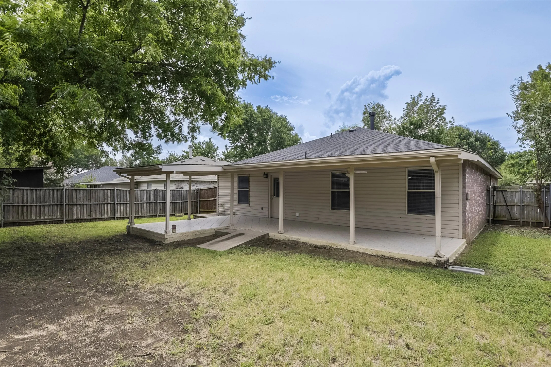 Expansive backyard featuring a covered patio, an additional covered tile patio, and a full perimeter wood fence