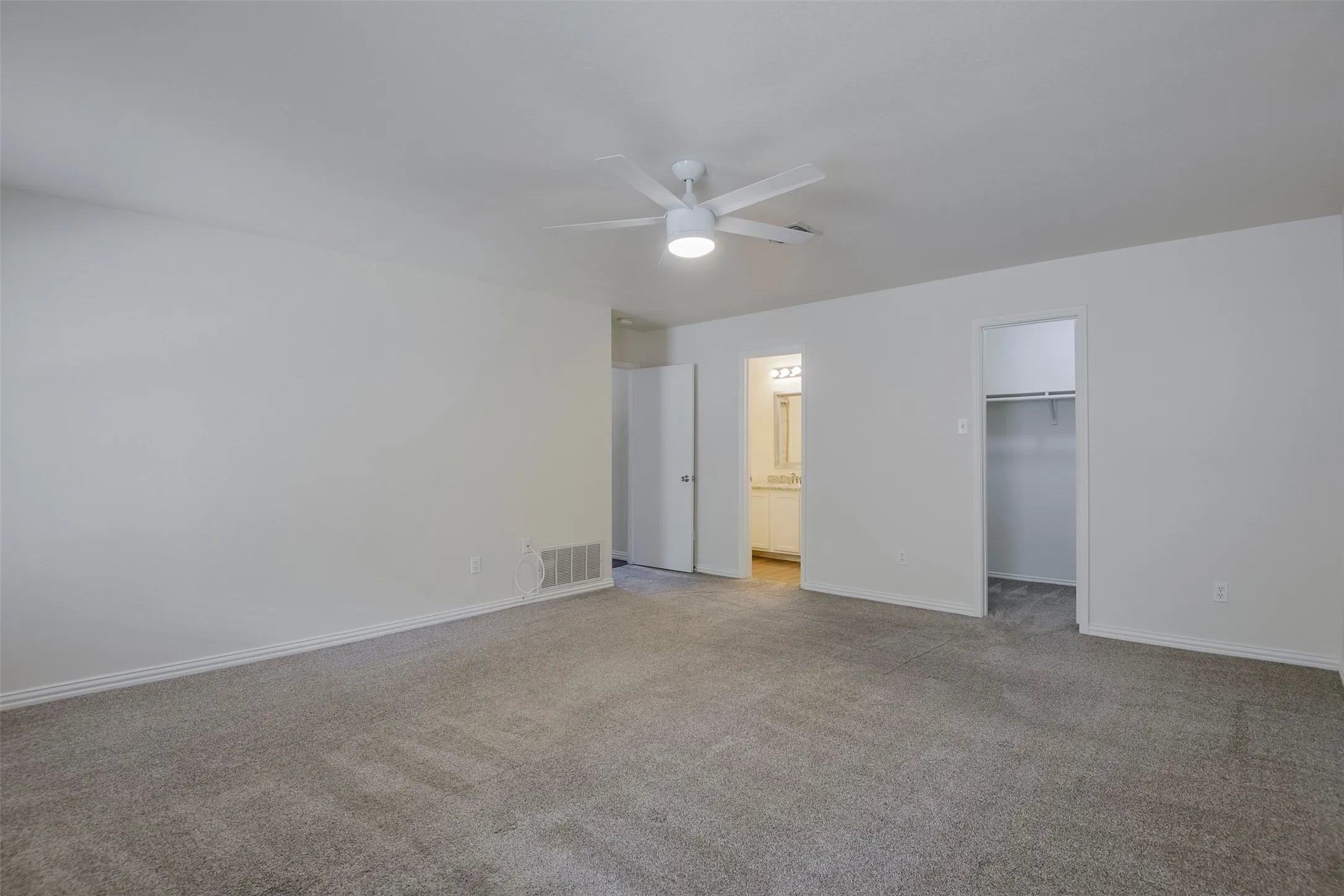 Spacious room featuring neutral carpeting and white walls