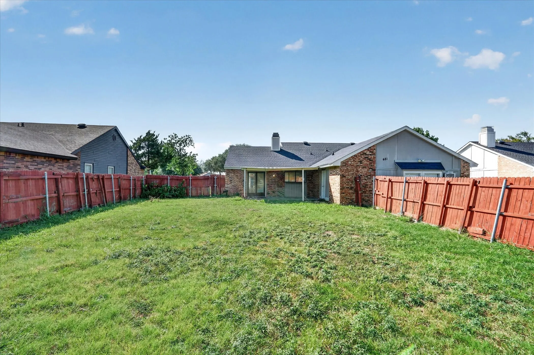 Expansive green space with a full privacy fence