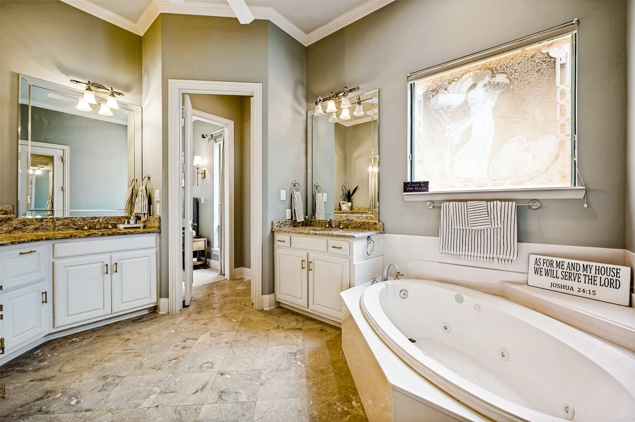 Dual vanity with integrated sinks, built-in soaking tub, tiled flooring, and framed mirrors