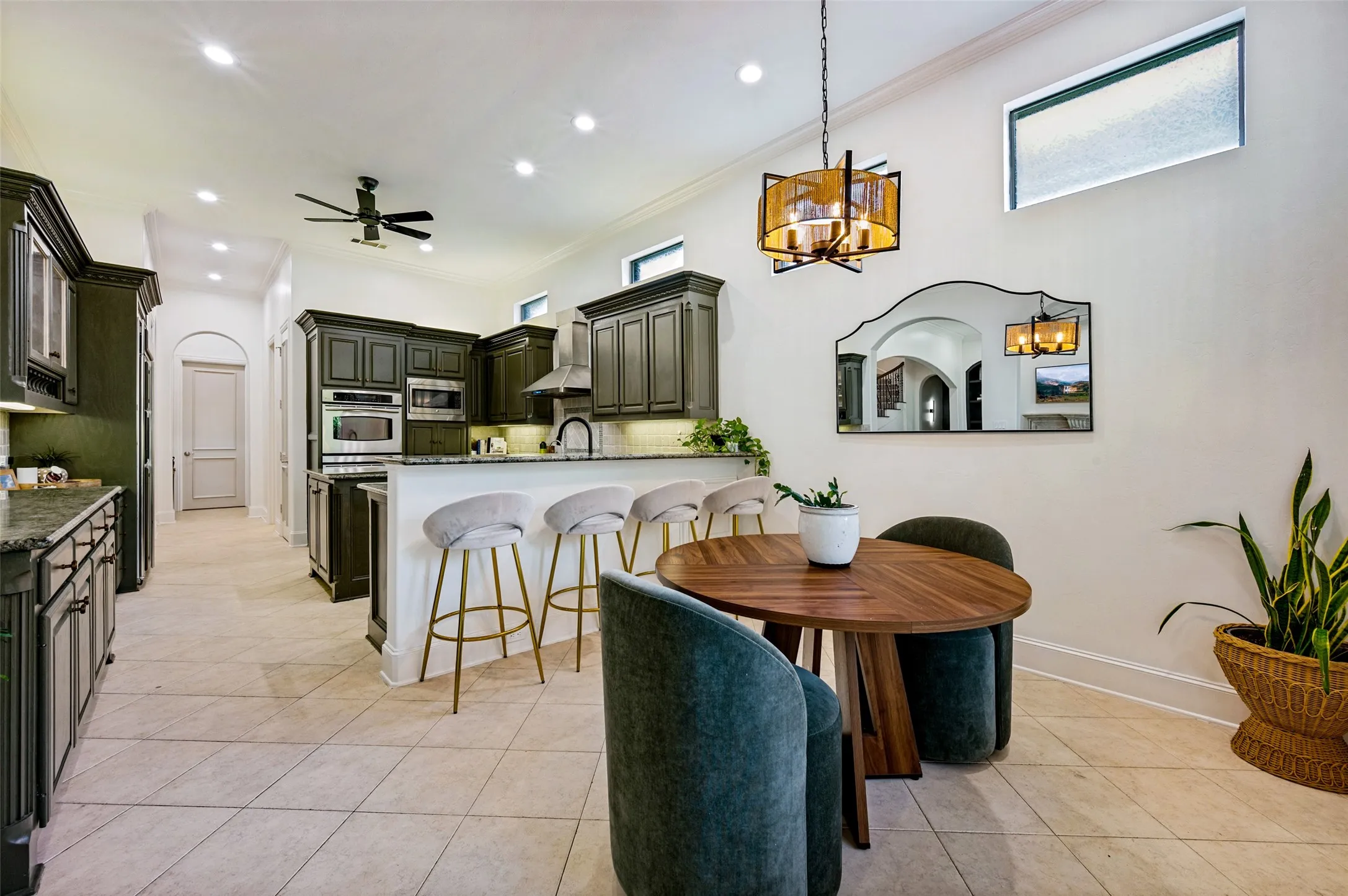 Kitchen featuring dark cabinetry, stainless steel appliances, a breakfast bar, recessed lighting, and tile flooring