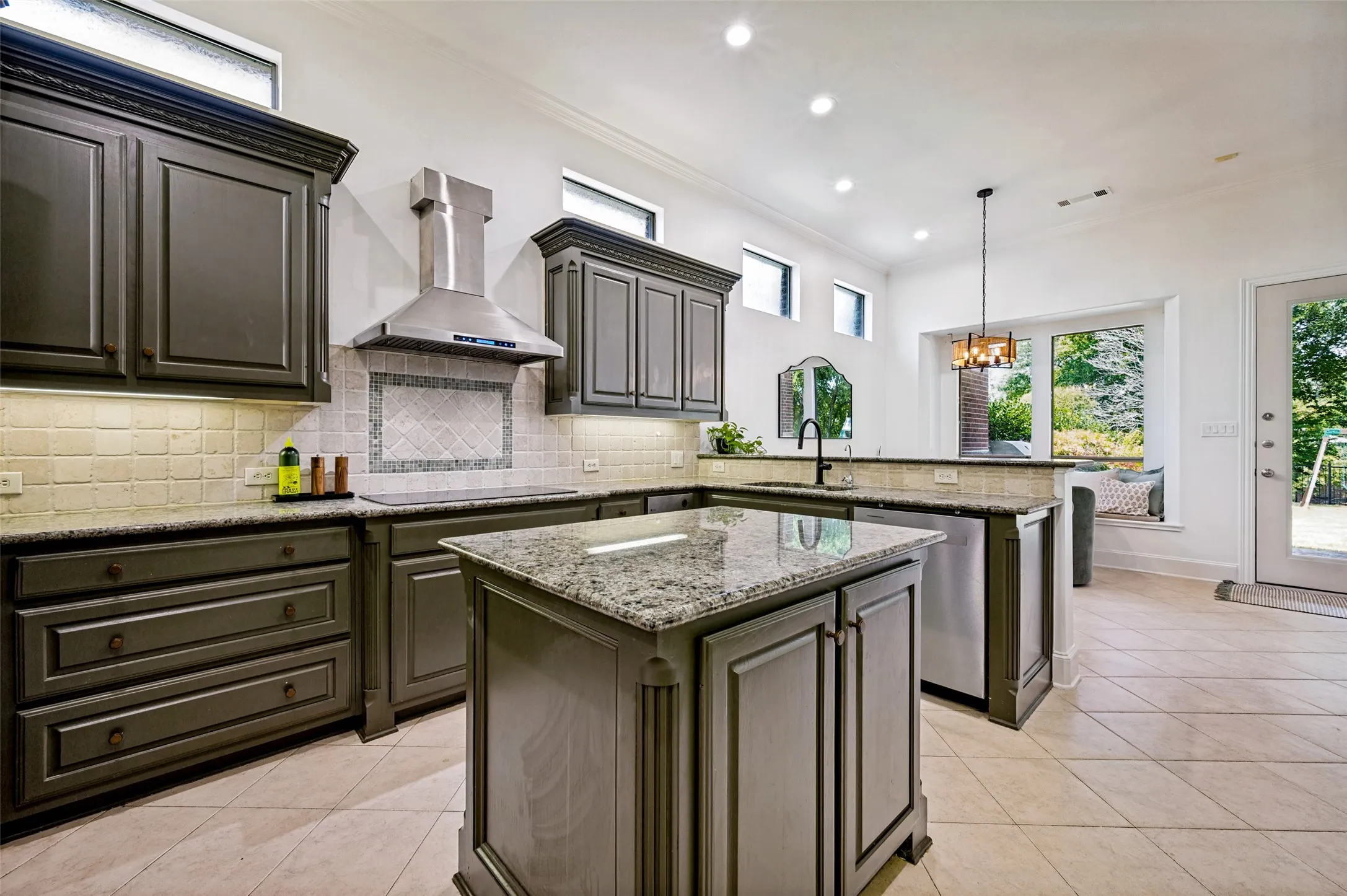 Kitchen featuring a central island, dark cabinetry, stainless steel appliances, granite countertops, and tile flooring
