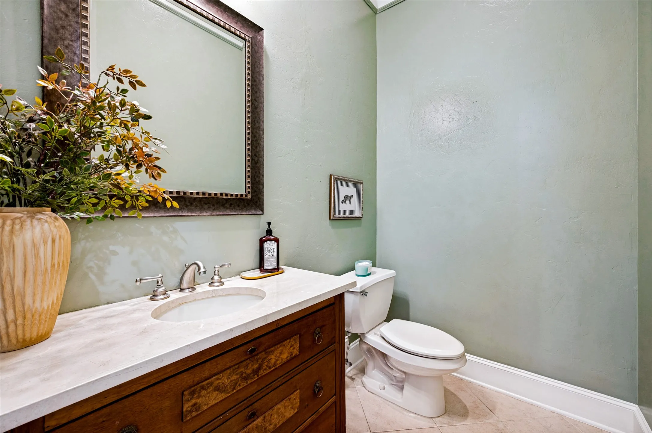 Vanity with integrated sink, polished chrome faucet, stone countertop, and wood-finish cabinetry