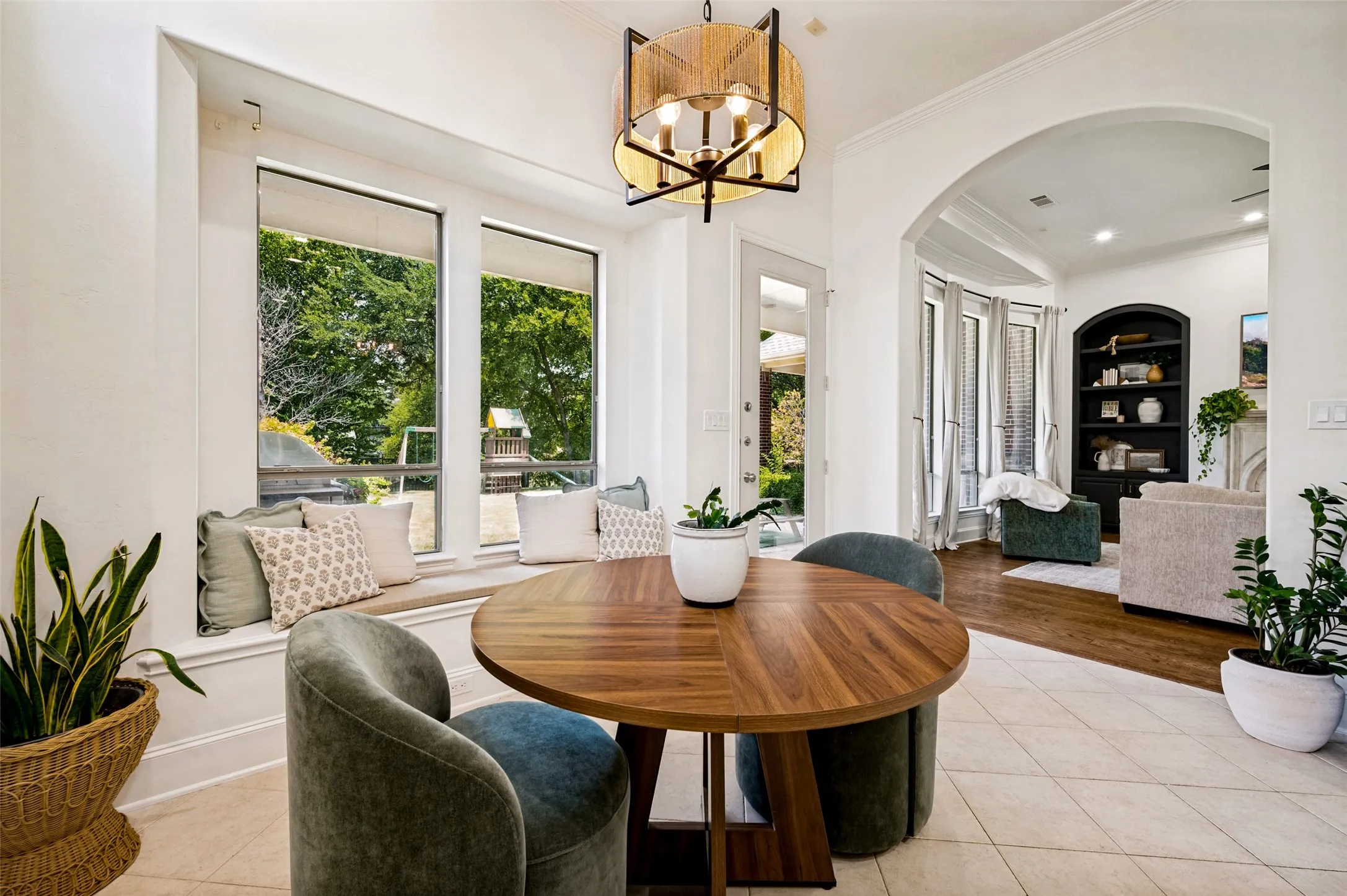 Arched entryway, built-in window seating, tile flooring, wood-finish flooring, and a decorative light fixture