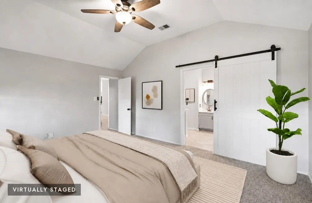 Vaulted ceiling with a ceiling fan light fixture, gray wall paint, and gray carpet flooring, virtually staged