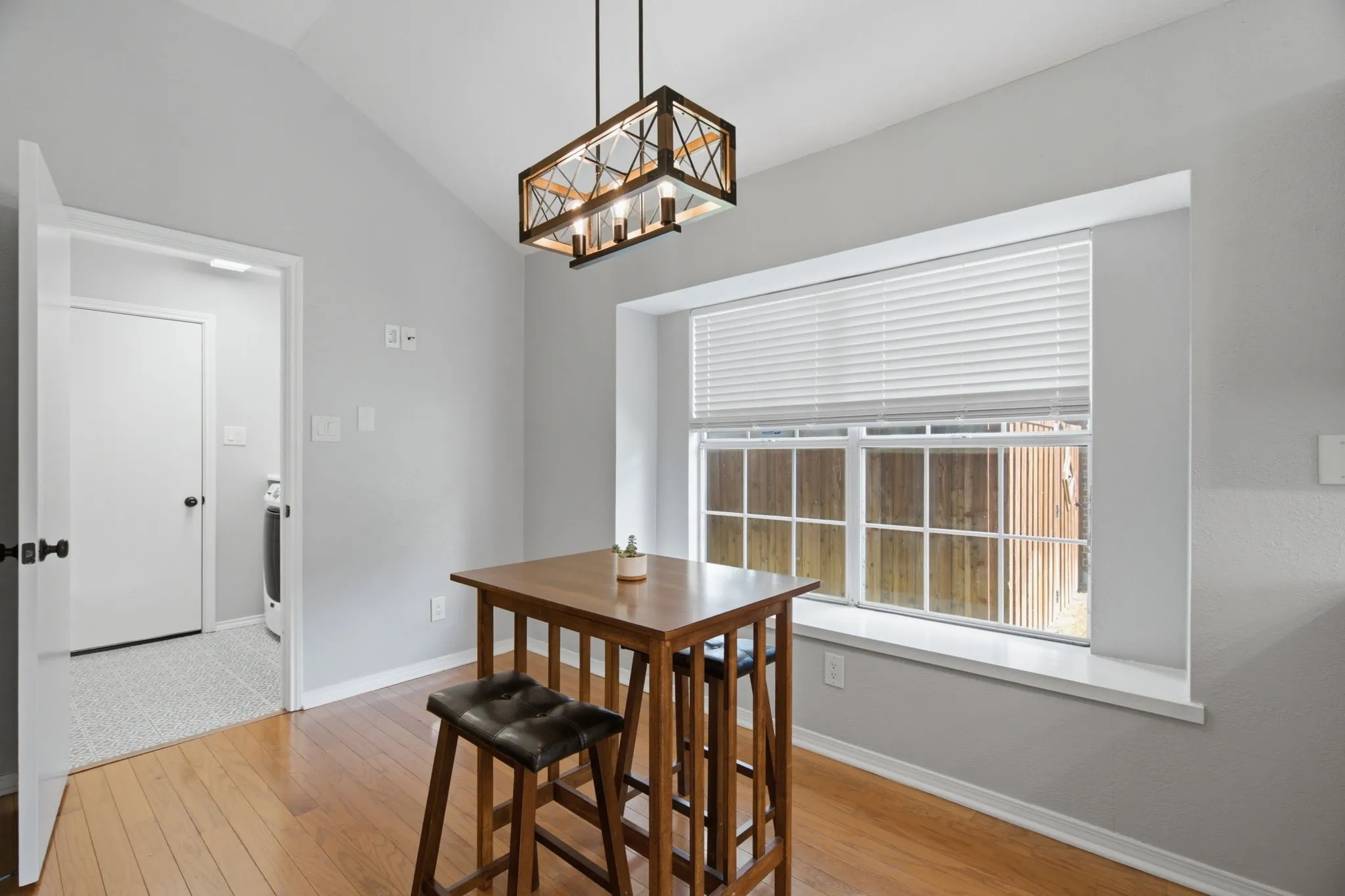 Dining area with wood-finish flooring and vaulted ceiling