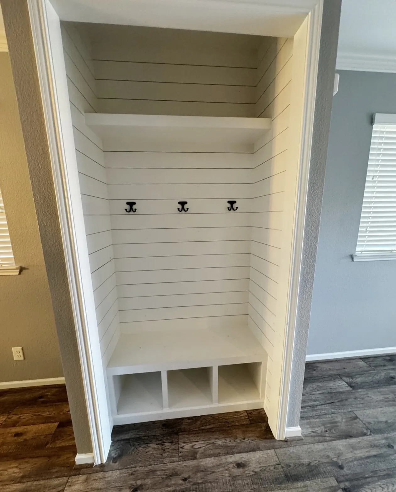 Built-in storage bench with three cubbies and three coat hooks