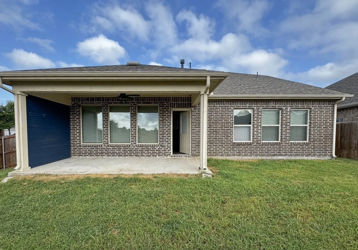 Covered patio with a ceiling fan, concrete flooring, and brick exterior