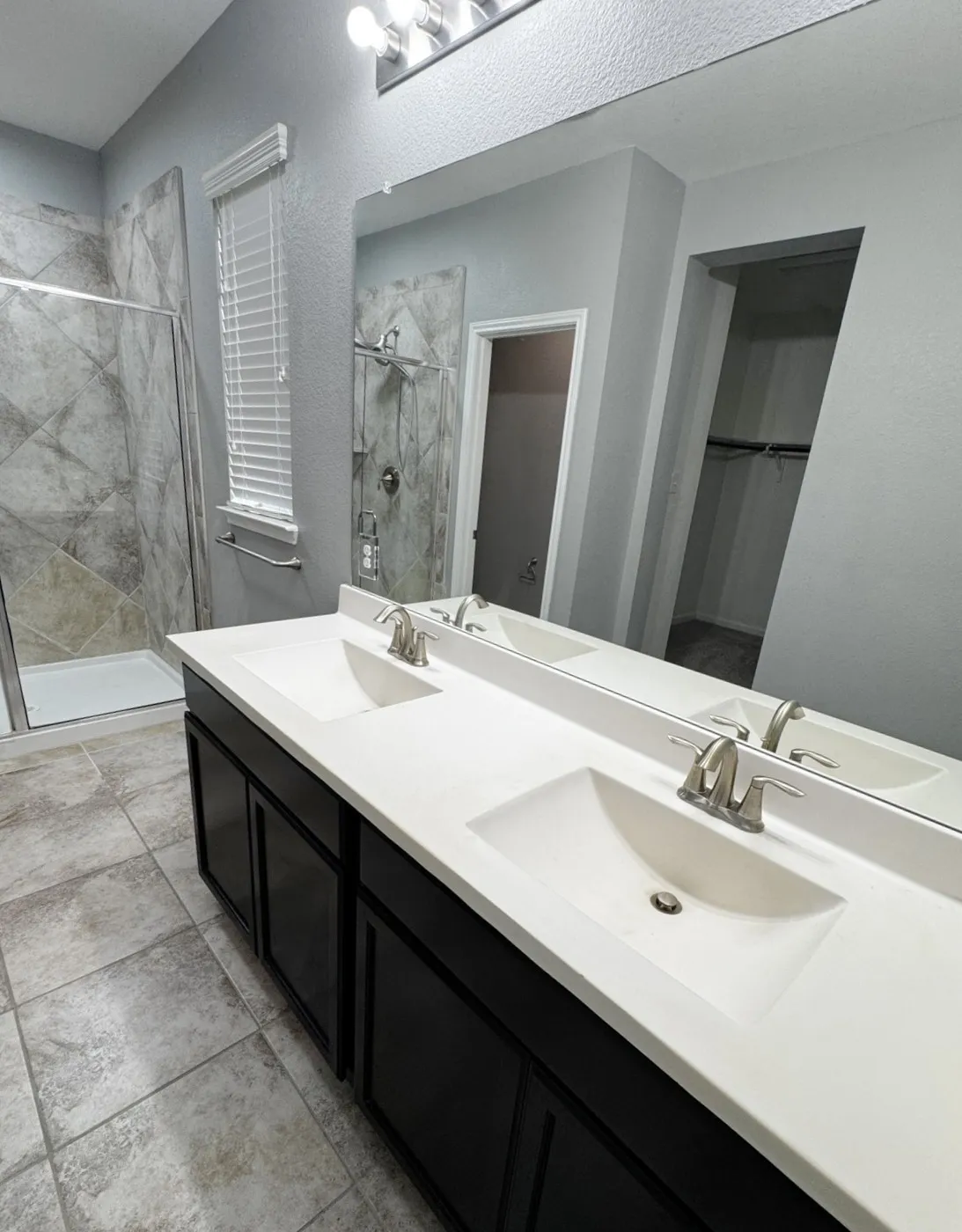 Dual vanity with integrated sinks, brushed nickel fixtures, and dark cabinetry