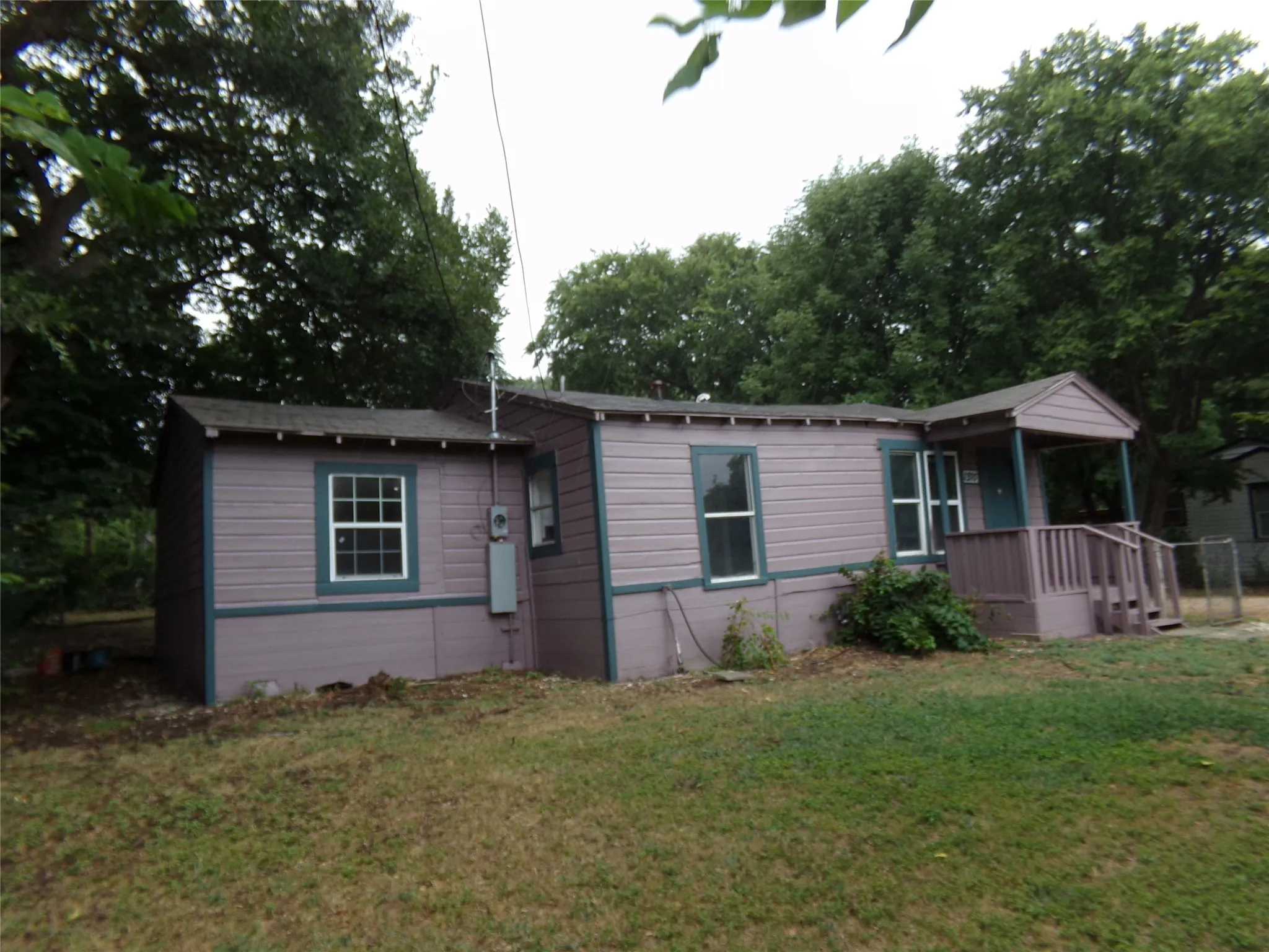 Single-story residence featuring horizontal siding, white-trimmed windows, and a covered porch entry