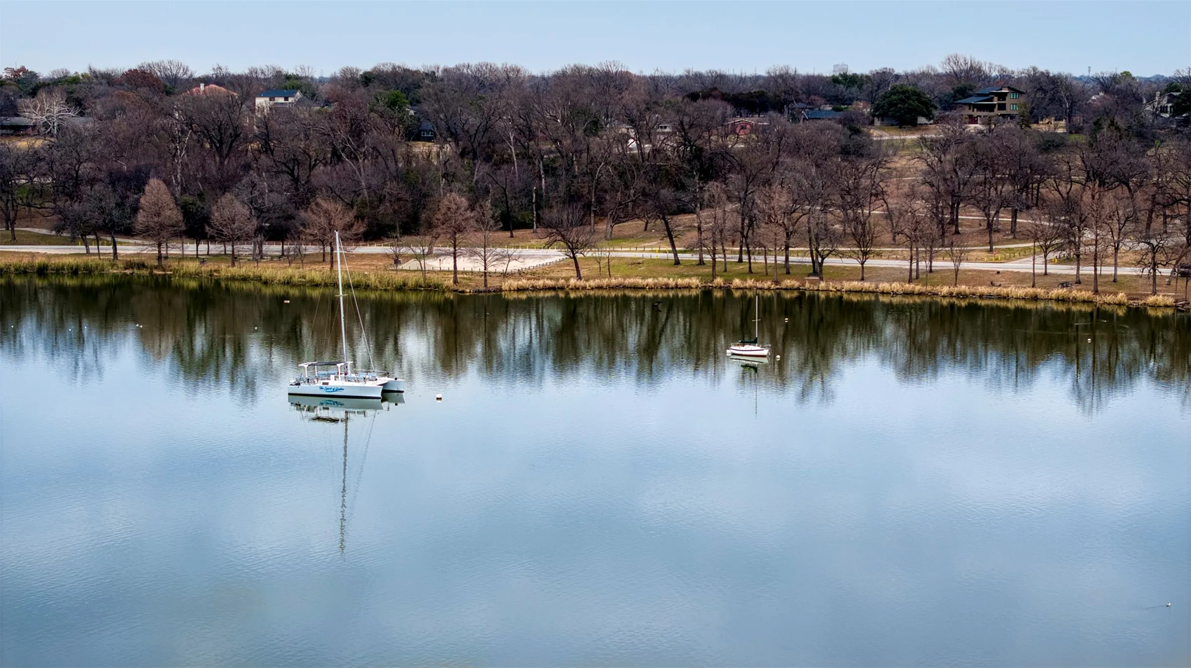 White Rock Lake Waterfront setting with a prominent lake, featuring two boats on the water