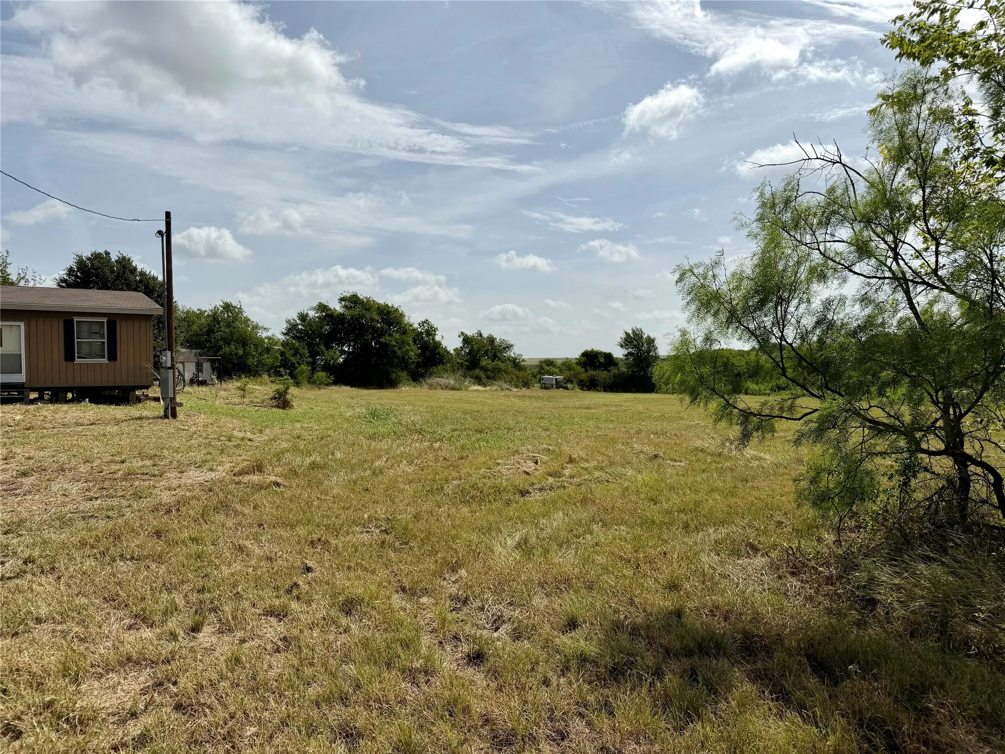 Expansive undeveloped land featuring natural vegetation and partial tree coverage