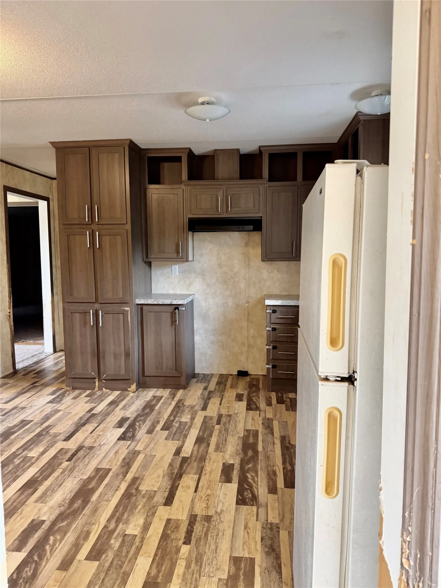 Kitchen featuring wood-finish flooring, recessed lighting, wood-finish cabinetry, and a built-in range hood