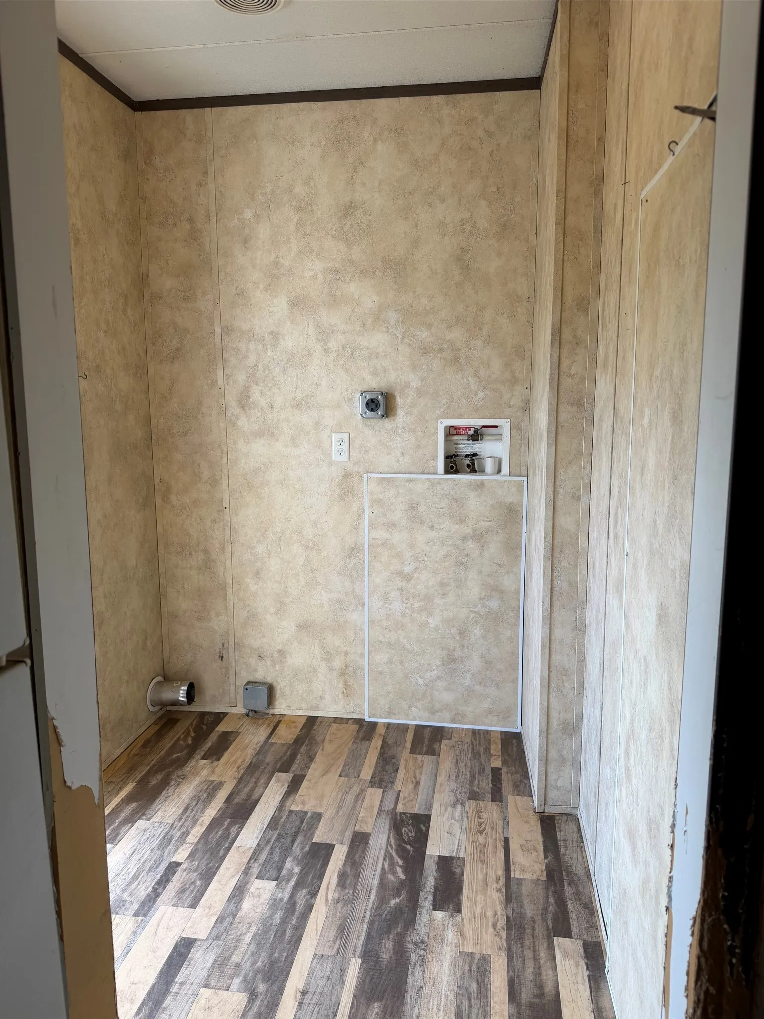 Dedicated utility space featuring wood-finish flooring and panel walls