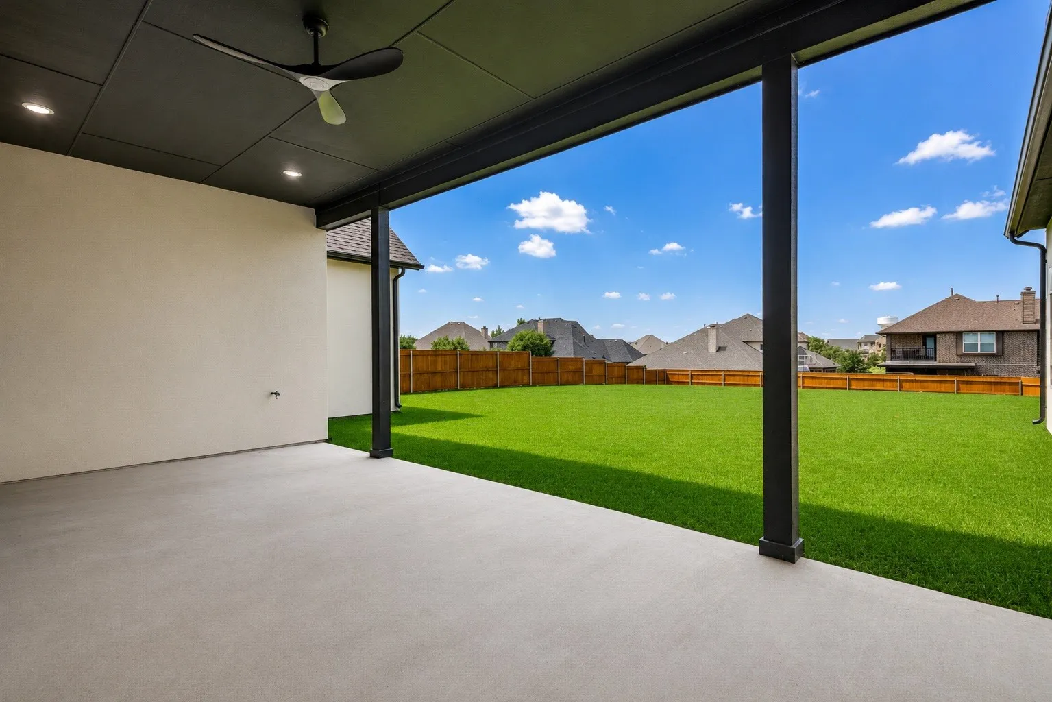 Covered patio with a concrete surface, black ceiling, recessed lighting, and a modern ceiling fan
