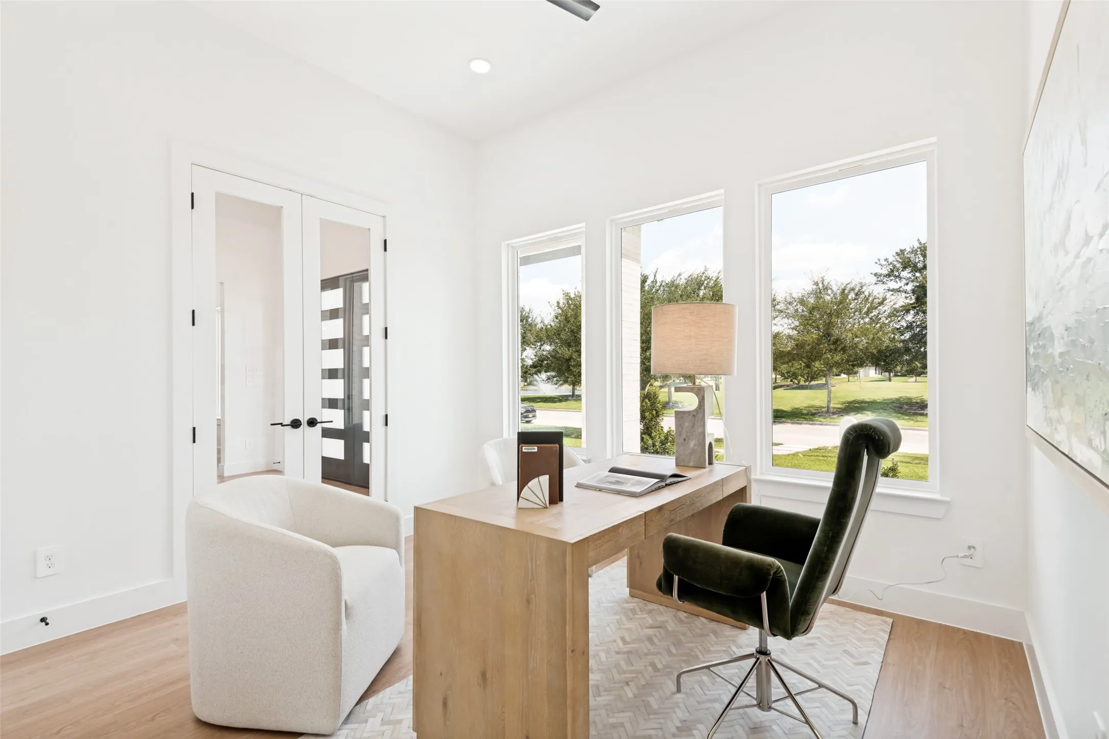 Dedicated office space featuring expansive windows, wood-finish flooring, recessed lighting, and double glass-paneled doors