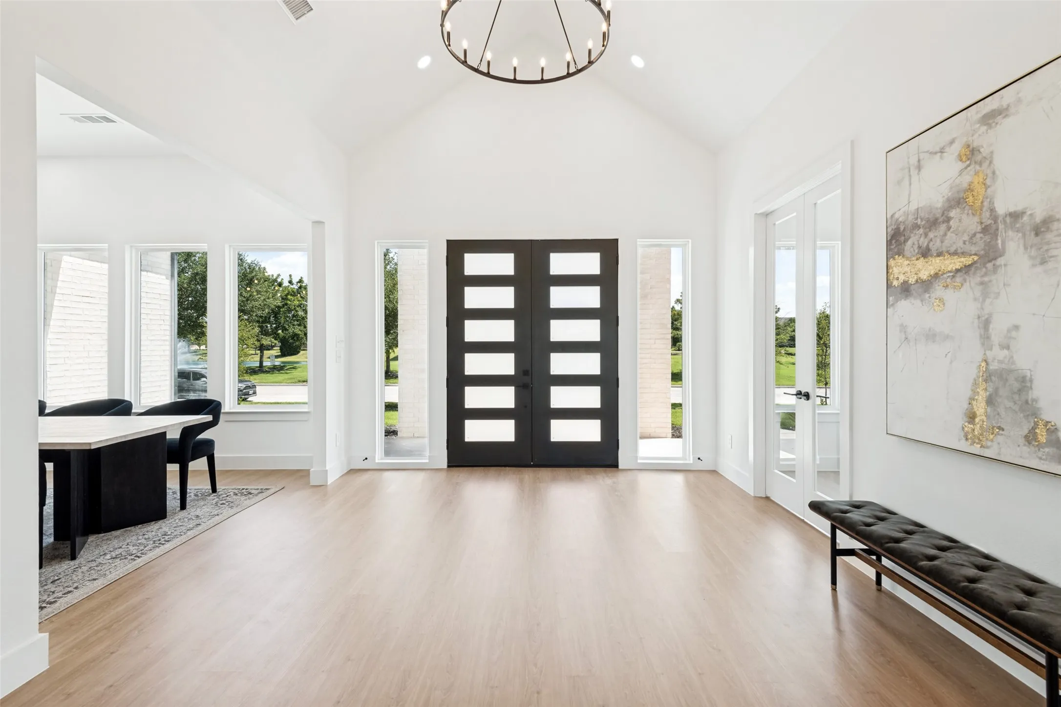 Grand entryway featuring a vaulted ceiling and light wood-finish flooring