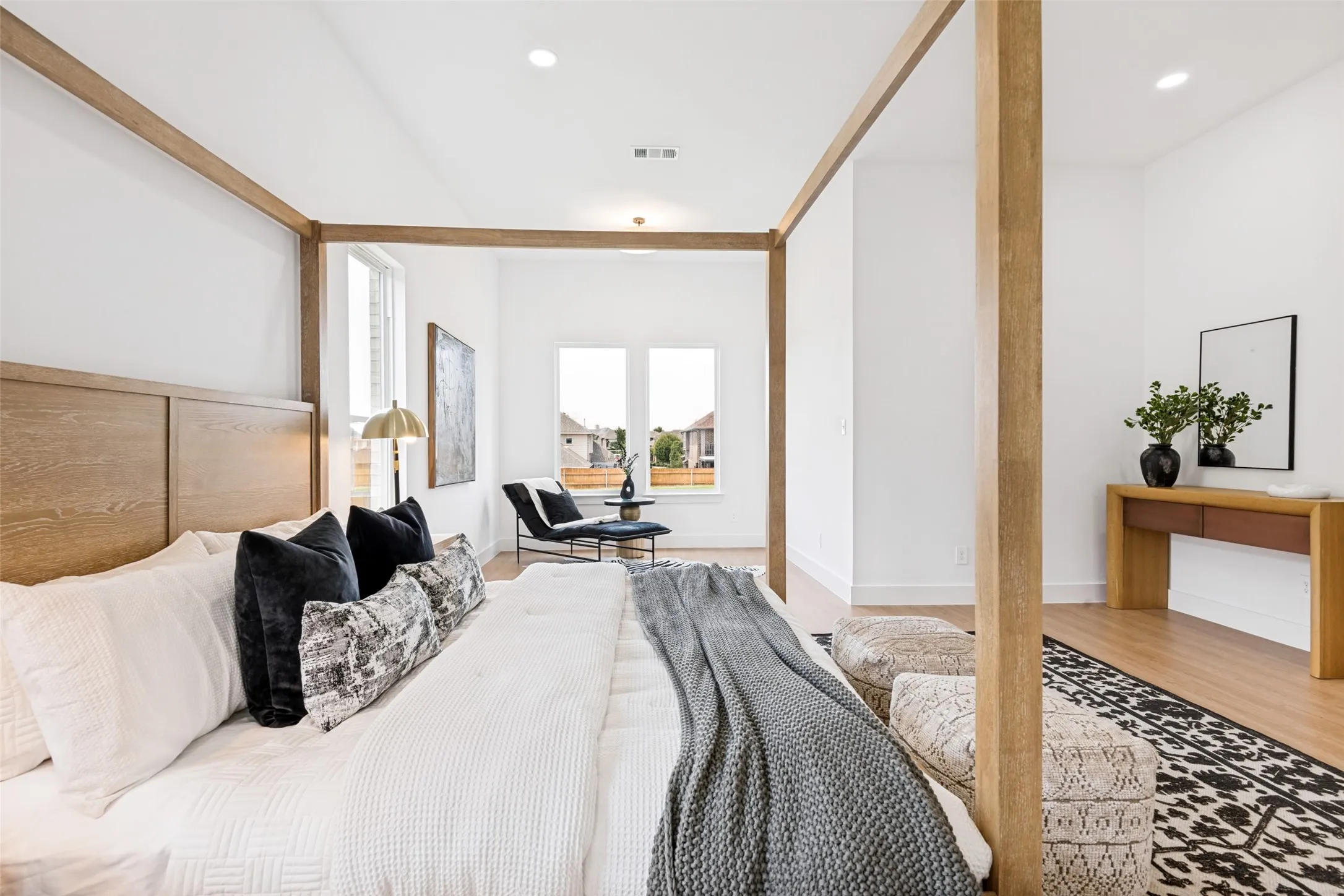 Open-concept room featuring light wood-finish flooring, white walls, recessed lighting, and multiple windows