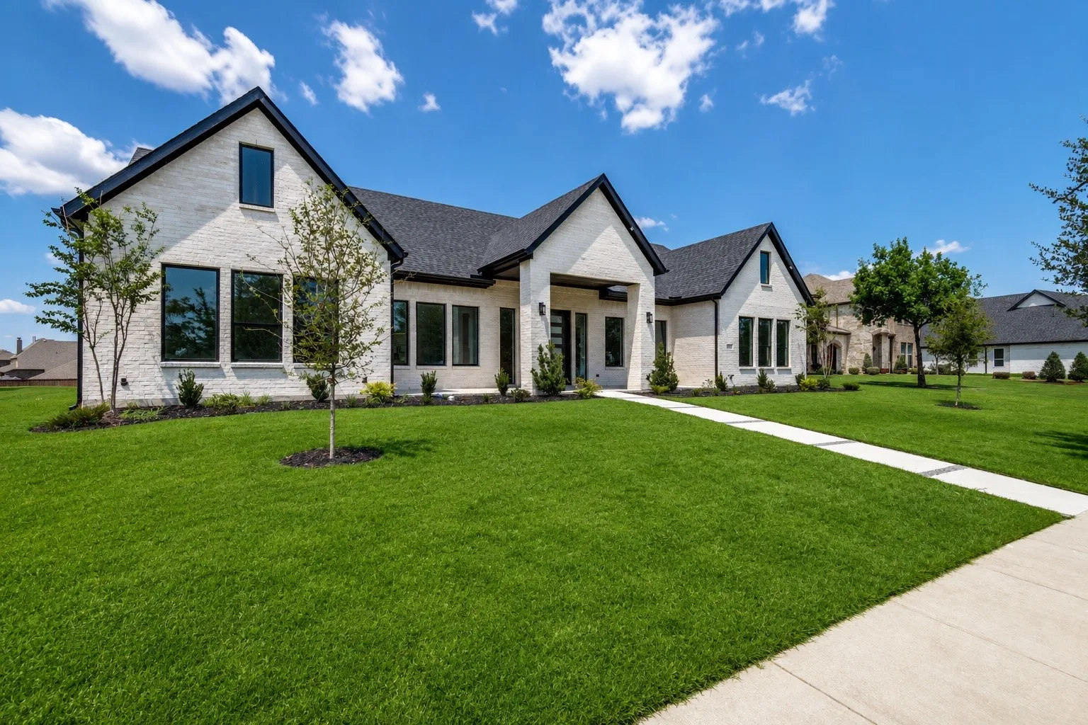 Contemporary home with a light-colored brick exterior and dark trim