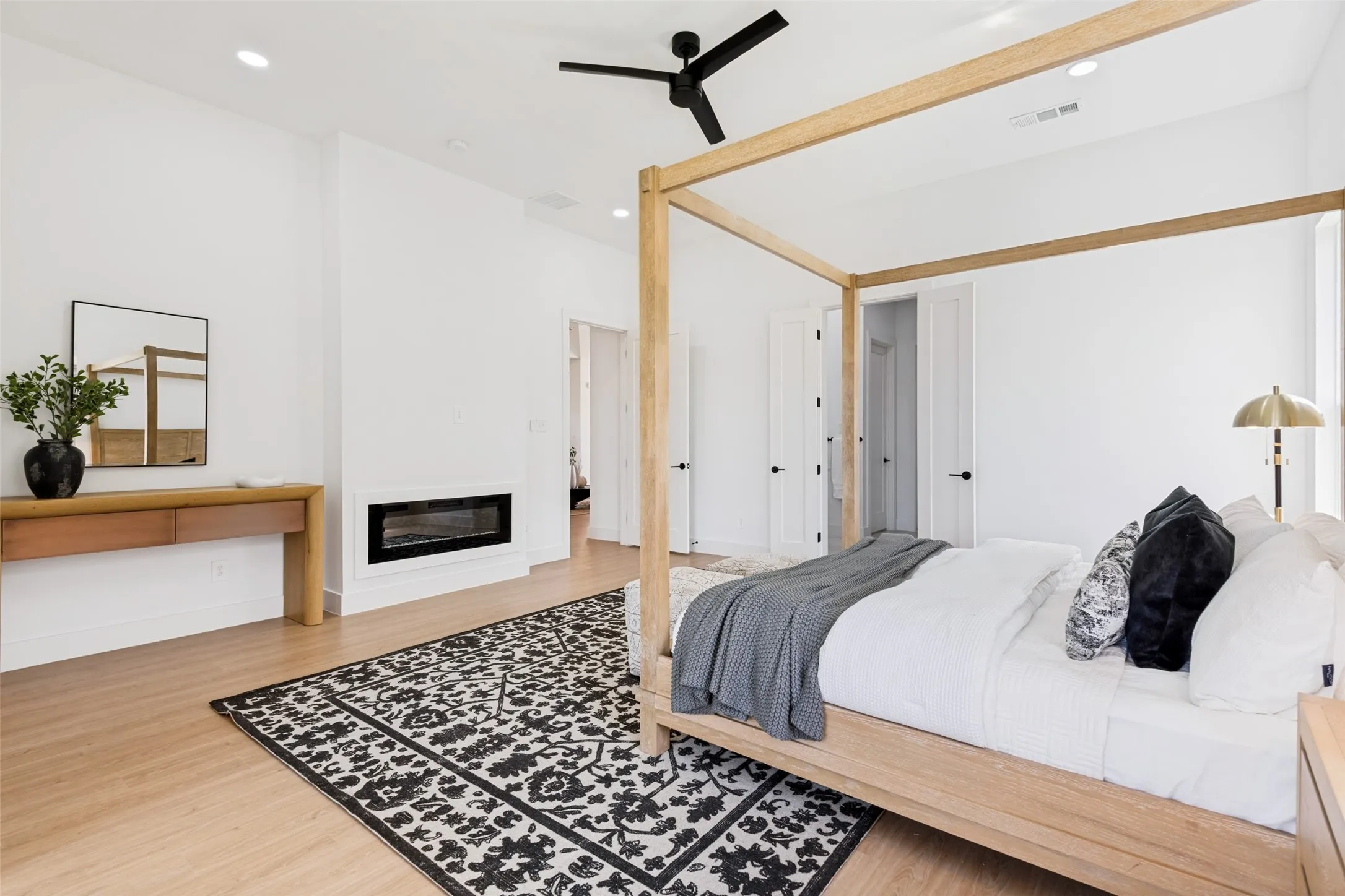Spacious room featuring wood-finish flooring, a contemporary linear fireplace, and recessed lighting