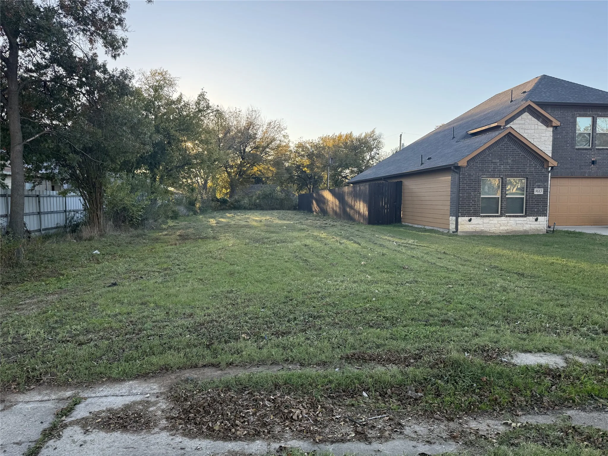 Expansive undeveloped lot featuring a grass expanse and mature trees along the perimeter