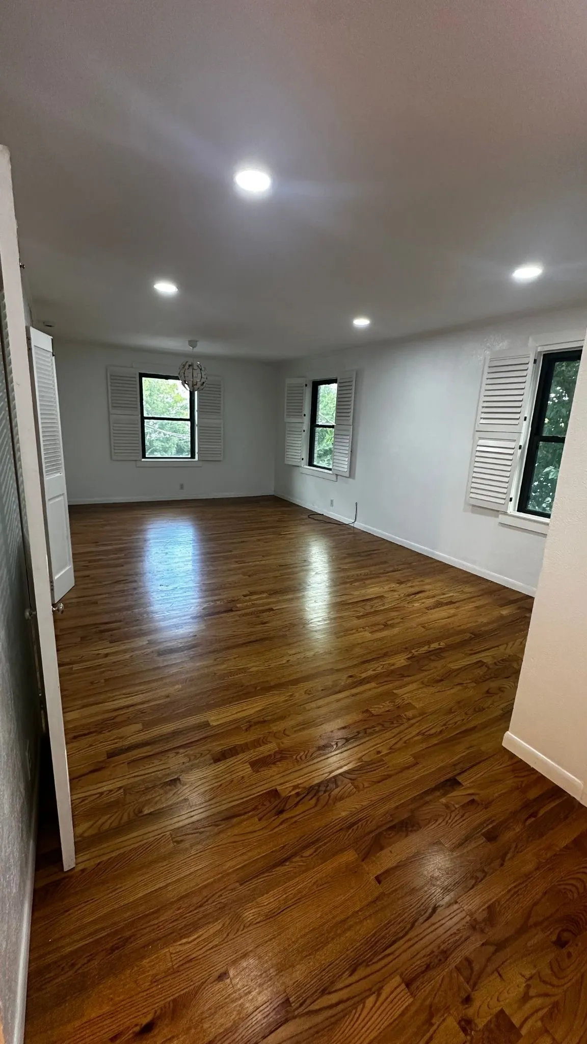 Spacious interior featuring wood-finish flooring, white walls, and recessed lighting