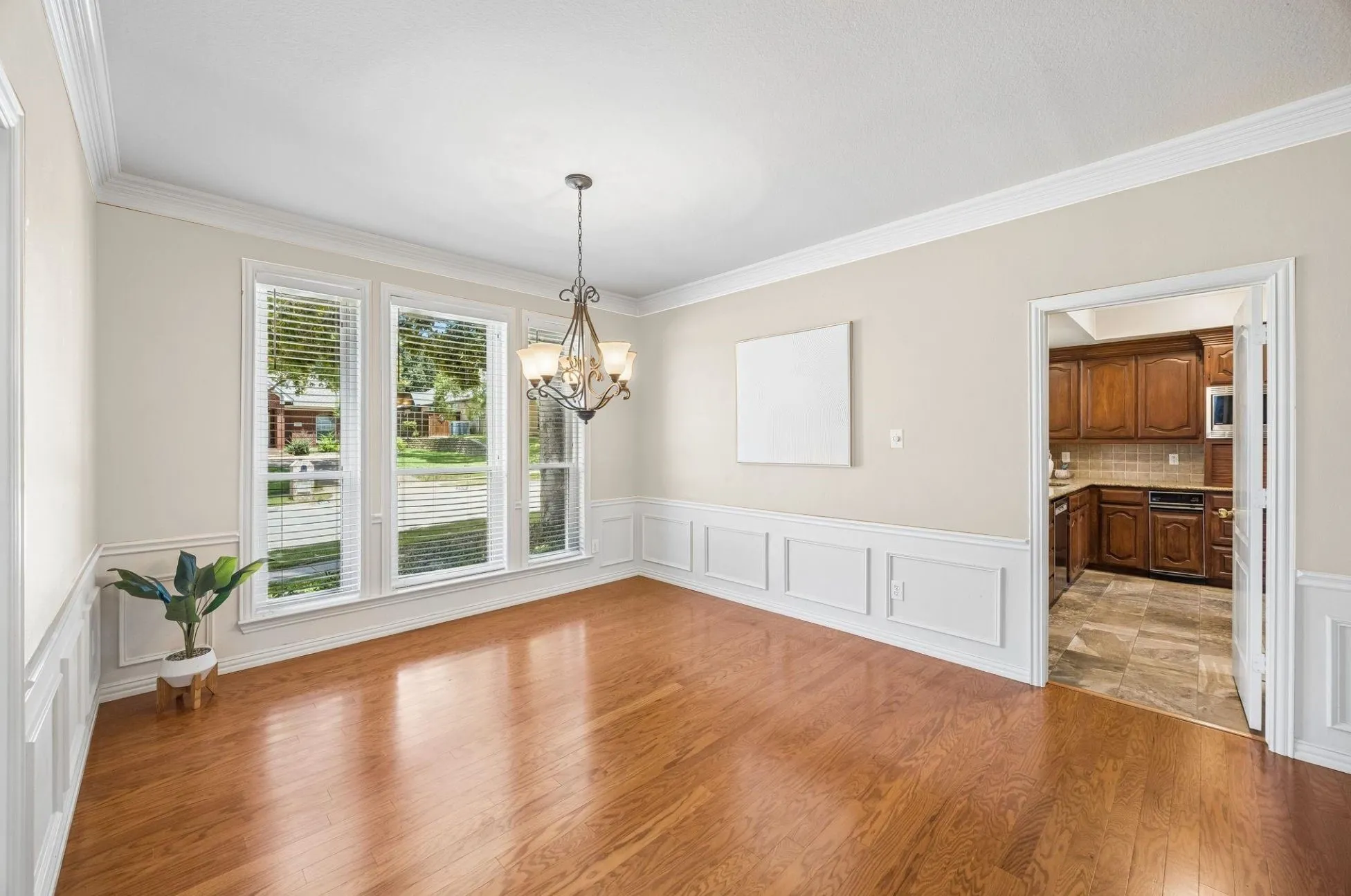 The dining room is accessed from the opposite side of the entry. The room offers great flow for entertaining with direct access to the kitchen and open flow to the other living spaces. The dining room has wood flooring, wainscoting with chair rail and heavy crown moulding.