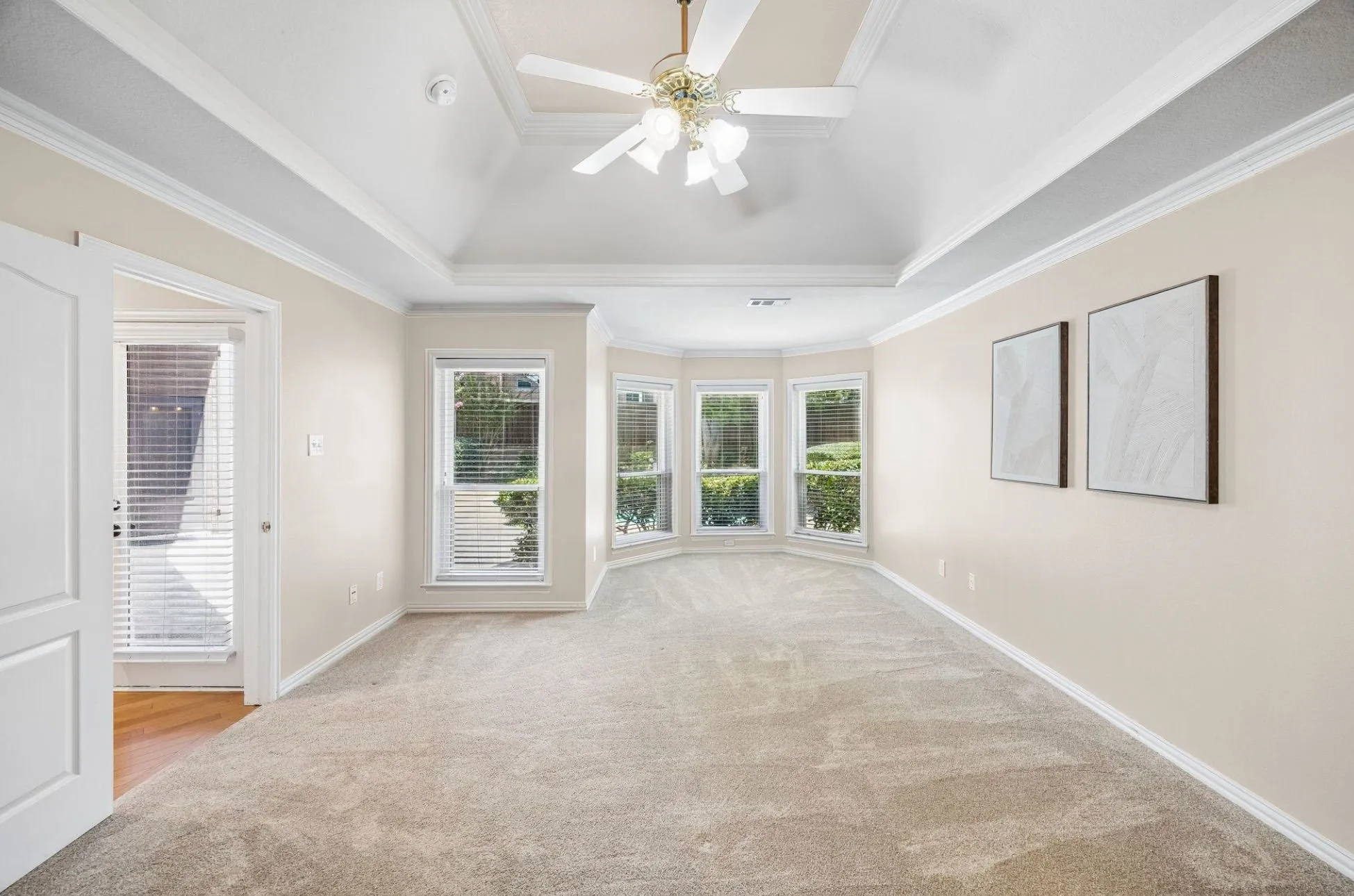 The spacious primary bedroom offers views of the outdoor oasis and room for a sitting area.