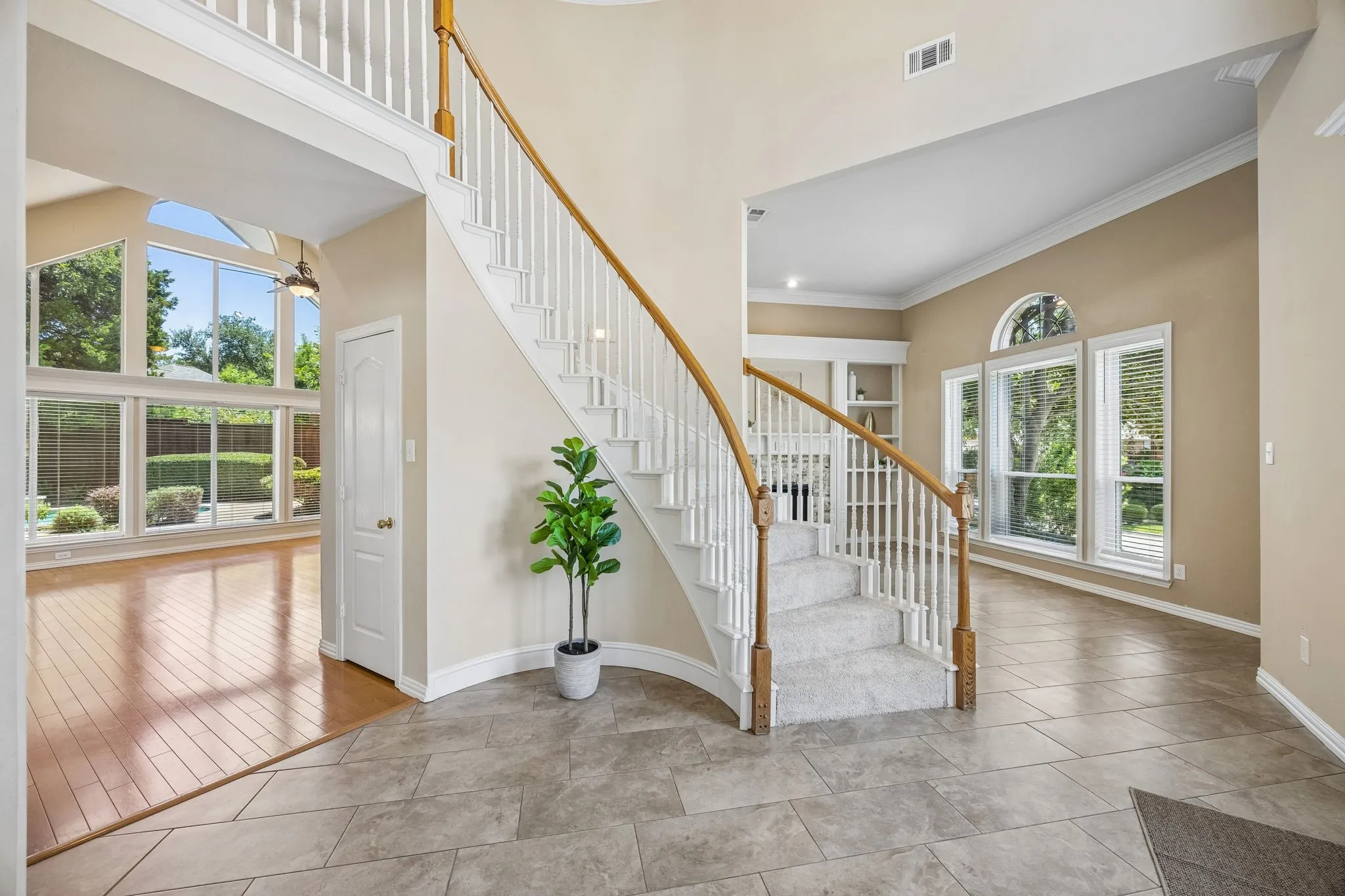 This view of the entry shows the great flow this home offers. The formal living to the right and the family room with an amazing wall of windows to the left. Impressive under the stair storage is found through the door shown.