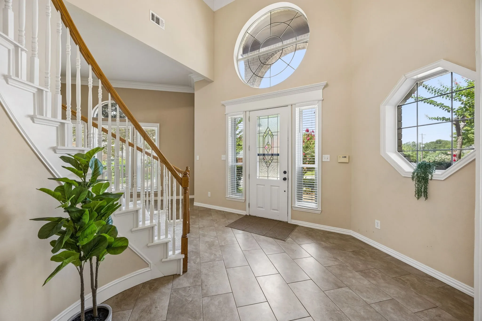 The open entry is graced by charming windows and oversized tile flooring.