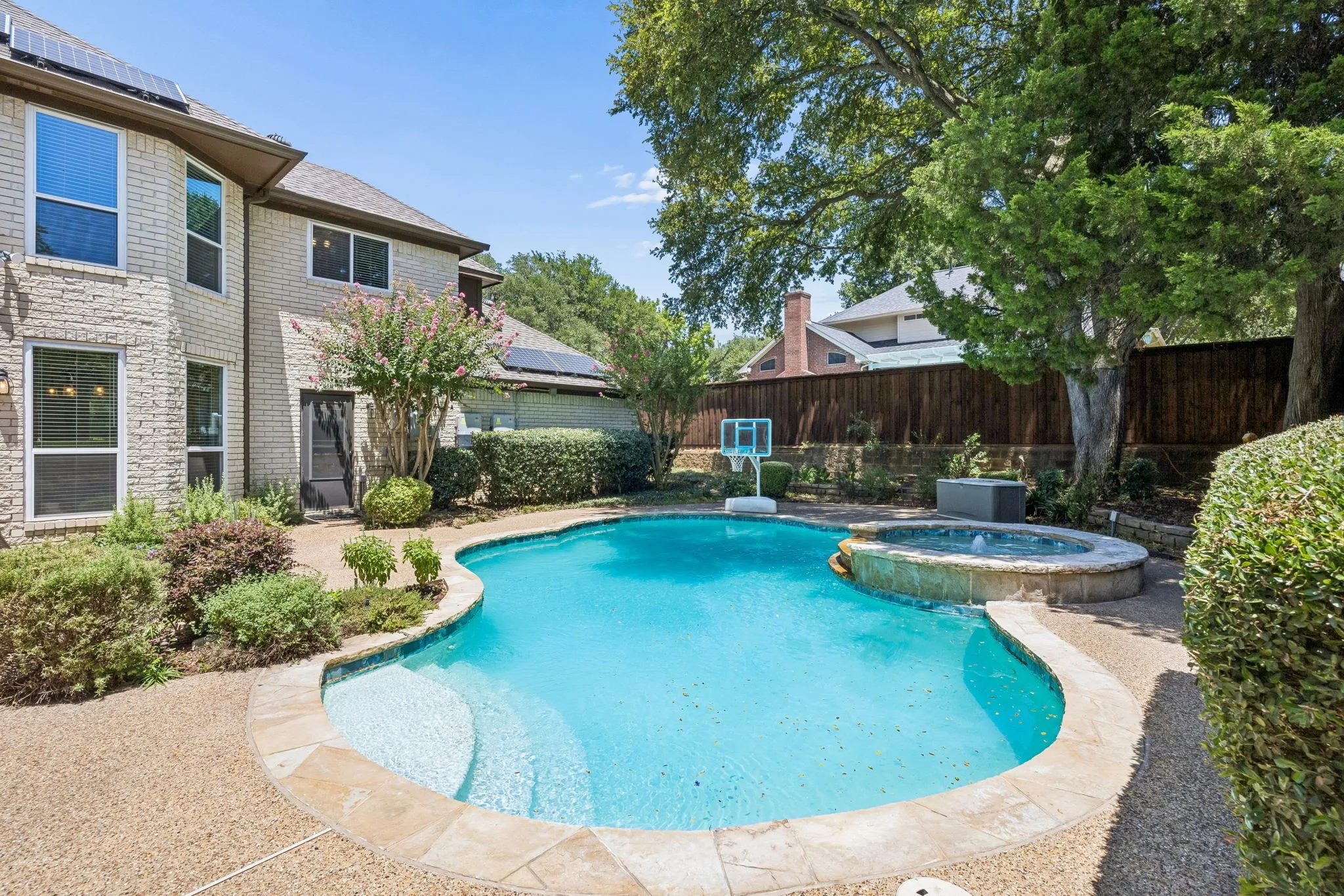 Another view of the pool. The wall of the home in the distance is the garage. There is a gate with garage access down a path to the right of the garage. The door shown gives direct access between the garage and the backyard.