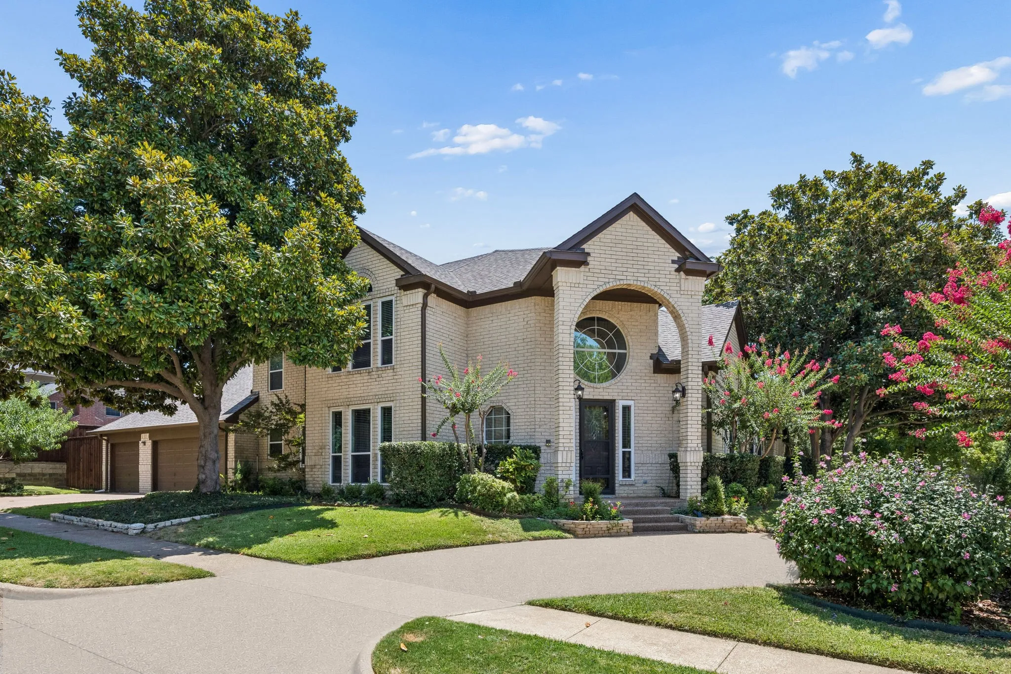 Beautiful home with stunning white brick and impressive front porch.