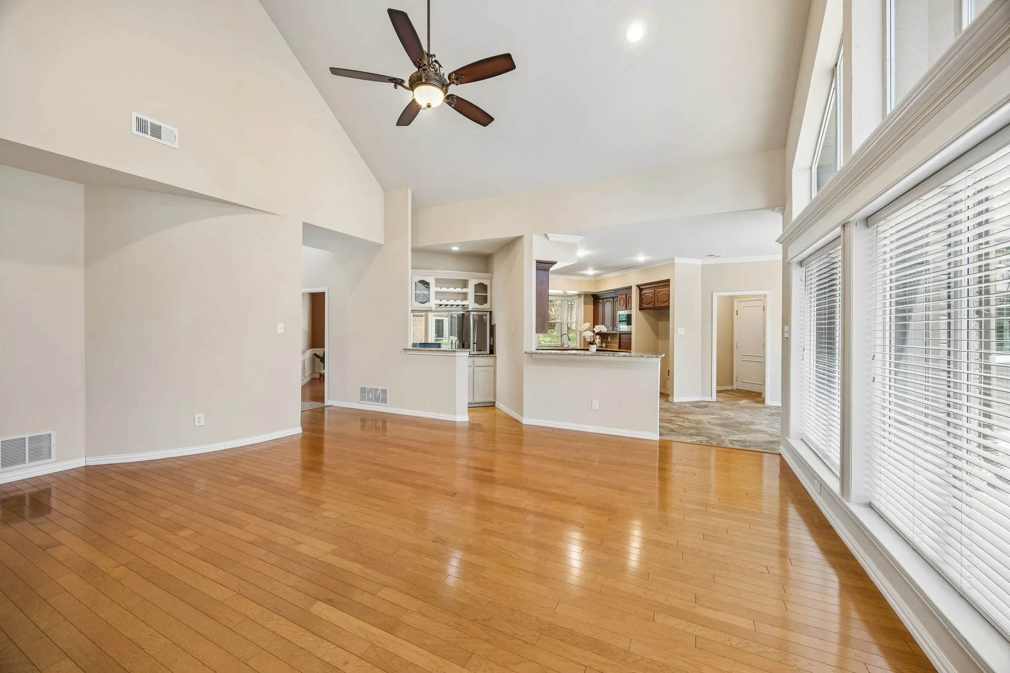 Looking across the family room to the kitchen. There is a convenient bar area and counter peninsula between the two areas. The room also offers ceiling fan and recessed lighting.