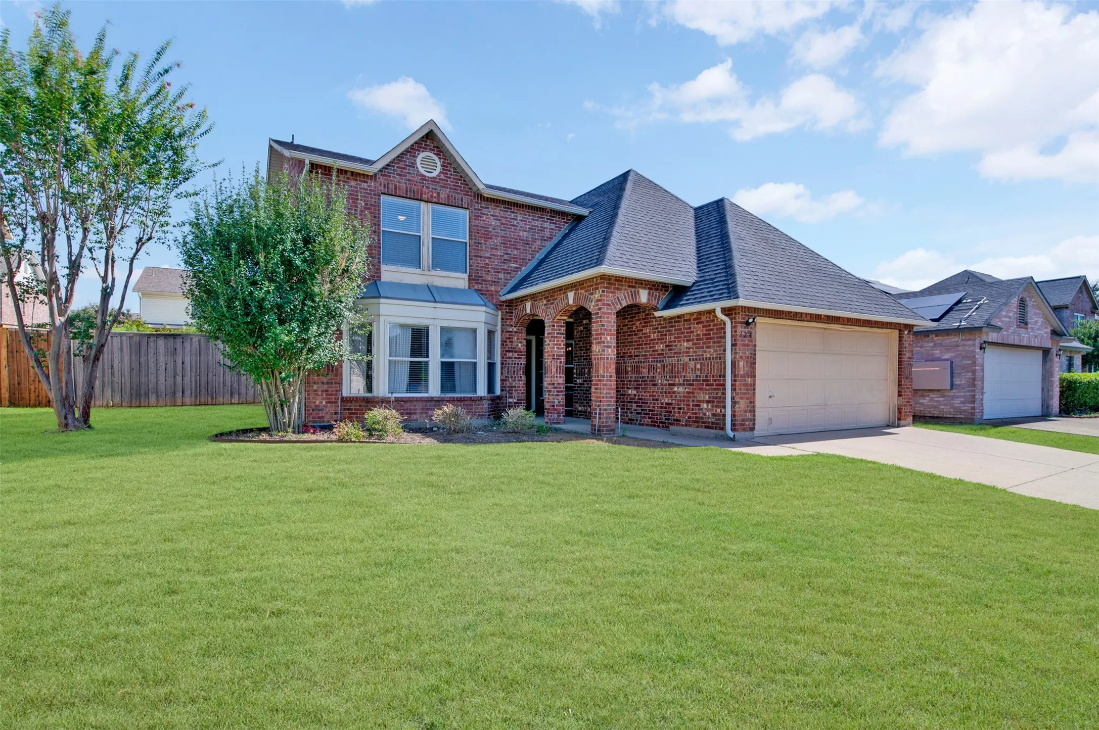 Brick facade residence featuring a prominent front gable and a two-story bay window