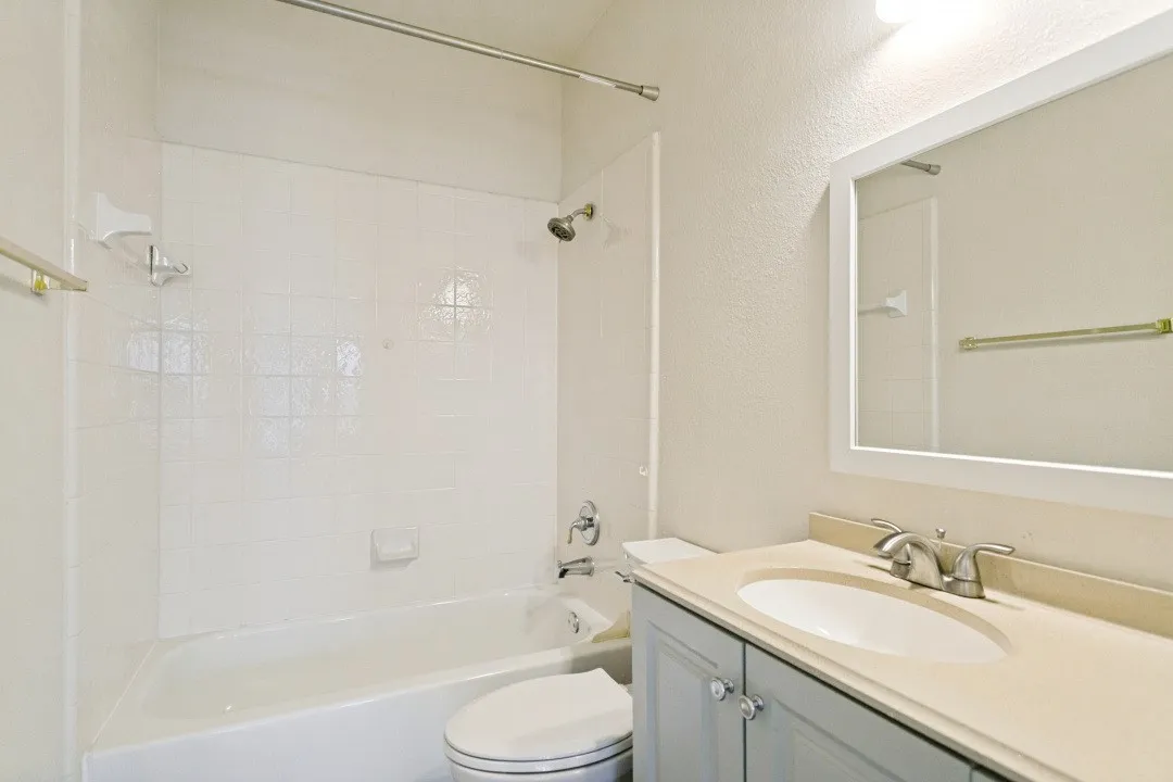 Bathroom featuring a full vanity with a light gray cabinet, a white oval sink, and a light-toned countertop