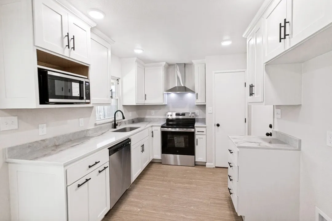 REDESIGNED KITCHEN WITH CUSTOM CABINETS AND MODERN APPLIANCES.