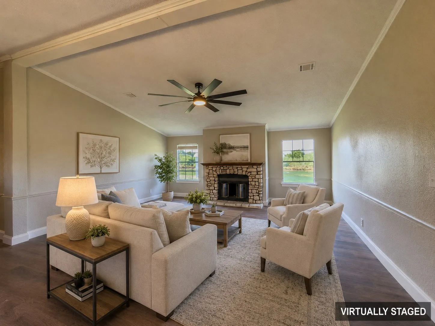 Living area featuring a stone-clad fireplace, wood-finish flooring, and a ceiling fan