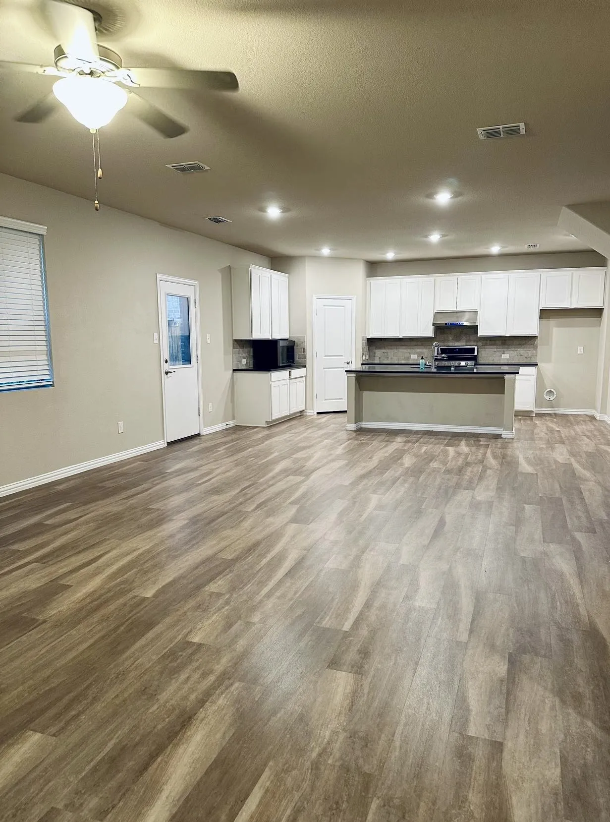 Unfurnished living room featuring hardwood / wood-style floors and ceiling fan
