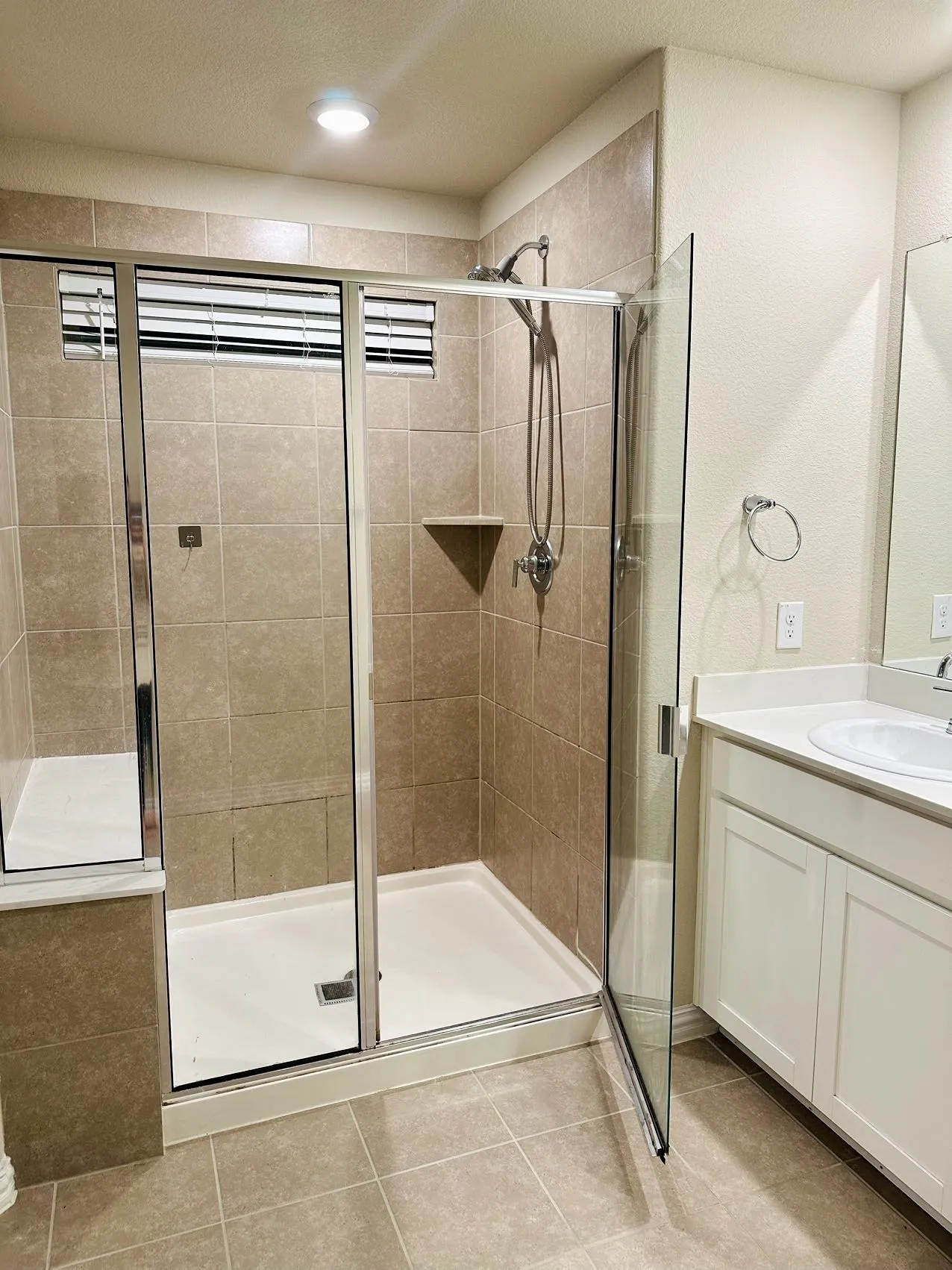 Bathroom with an enclosed shower, oversized vanity, tile flooring, and a textured​​‌​​​​‌​​‌‌​‌‌​​​‌‌​‌​‌​‌​​​‌​​ ceiling