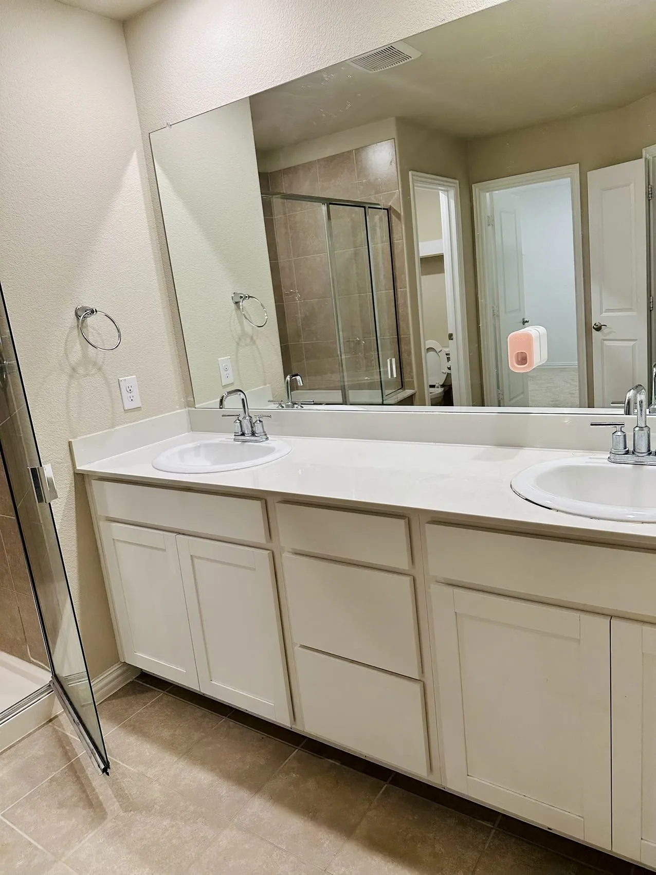 Bathroom featuring tile flooring, double sink vanity, and an enclosed shower