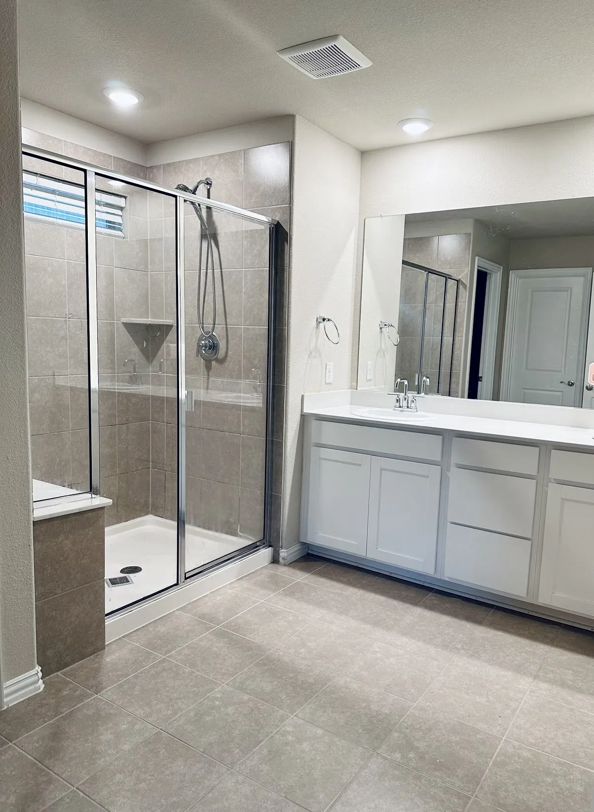 Bathroom with tile floors, walk in shower, a textured ceiling, and vanity