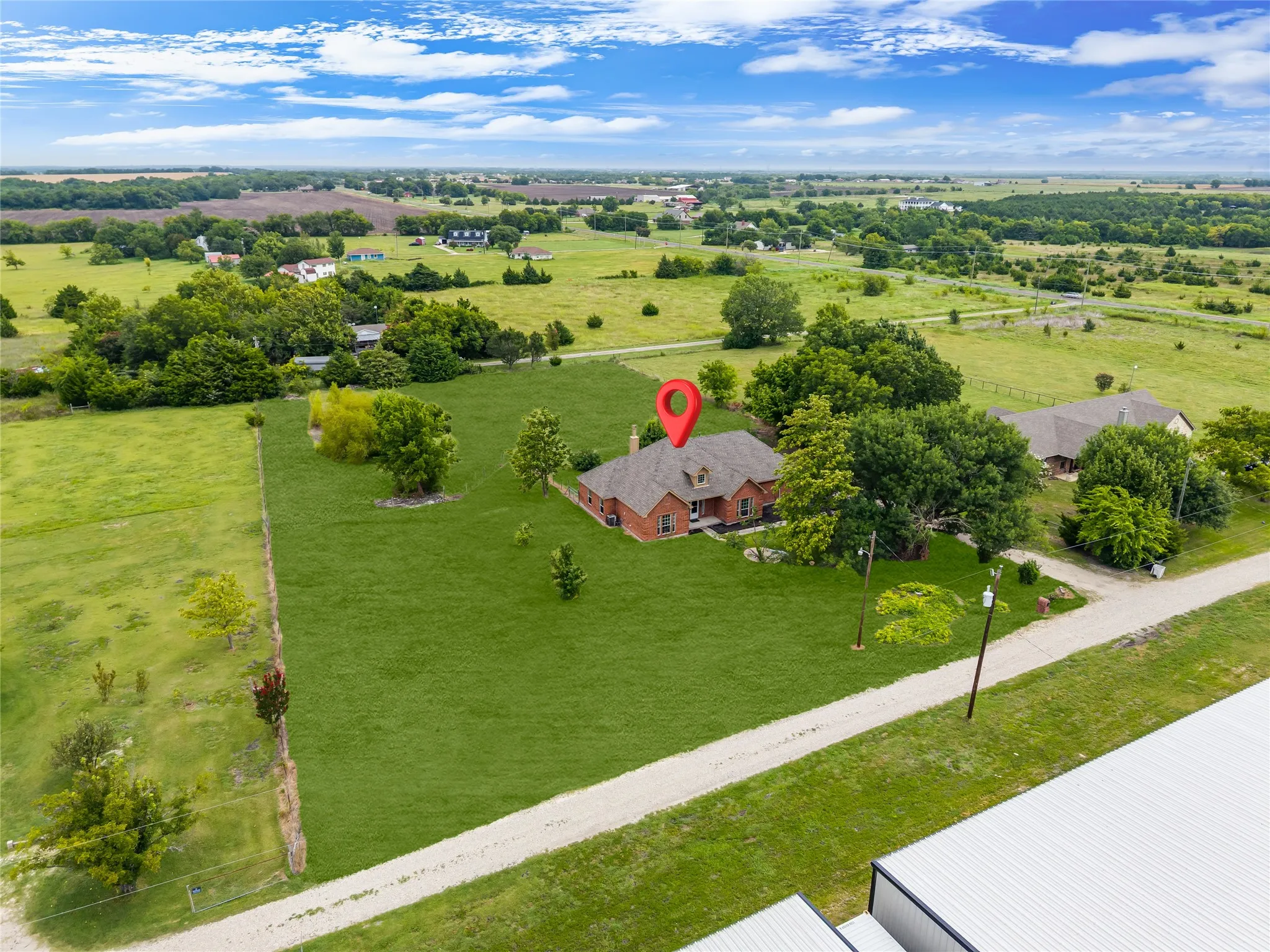 Red brick residence situated on a large grassy parcel