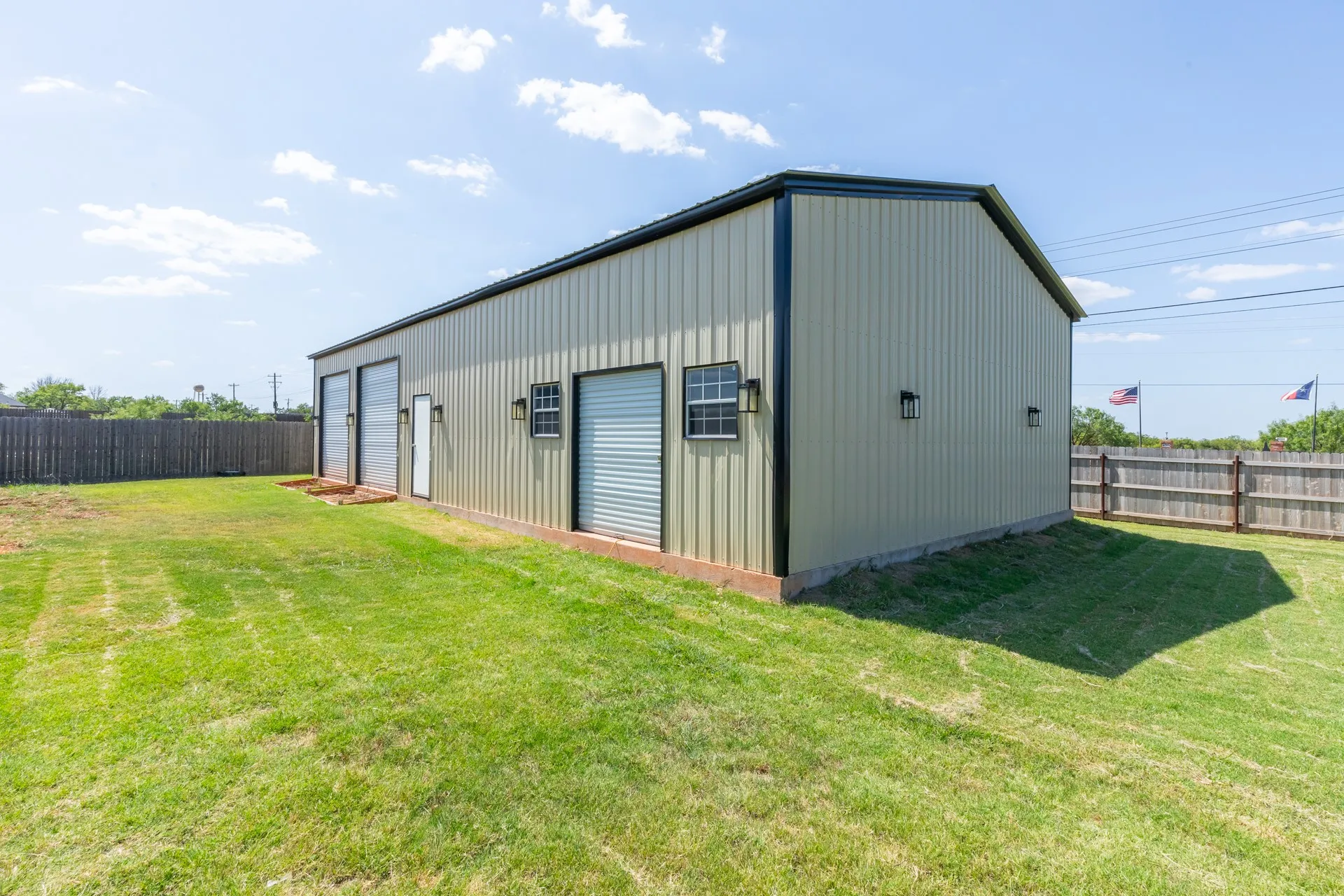 Metal outbuilding with a gabled roof and light-colored siding