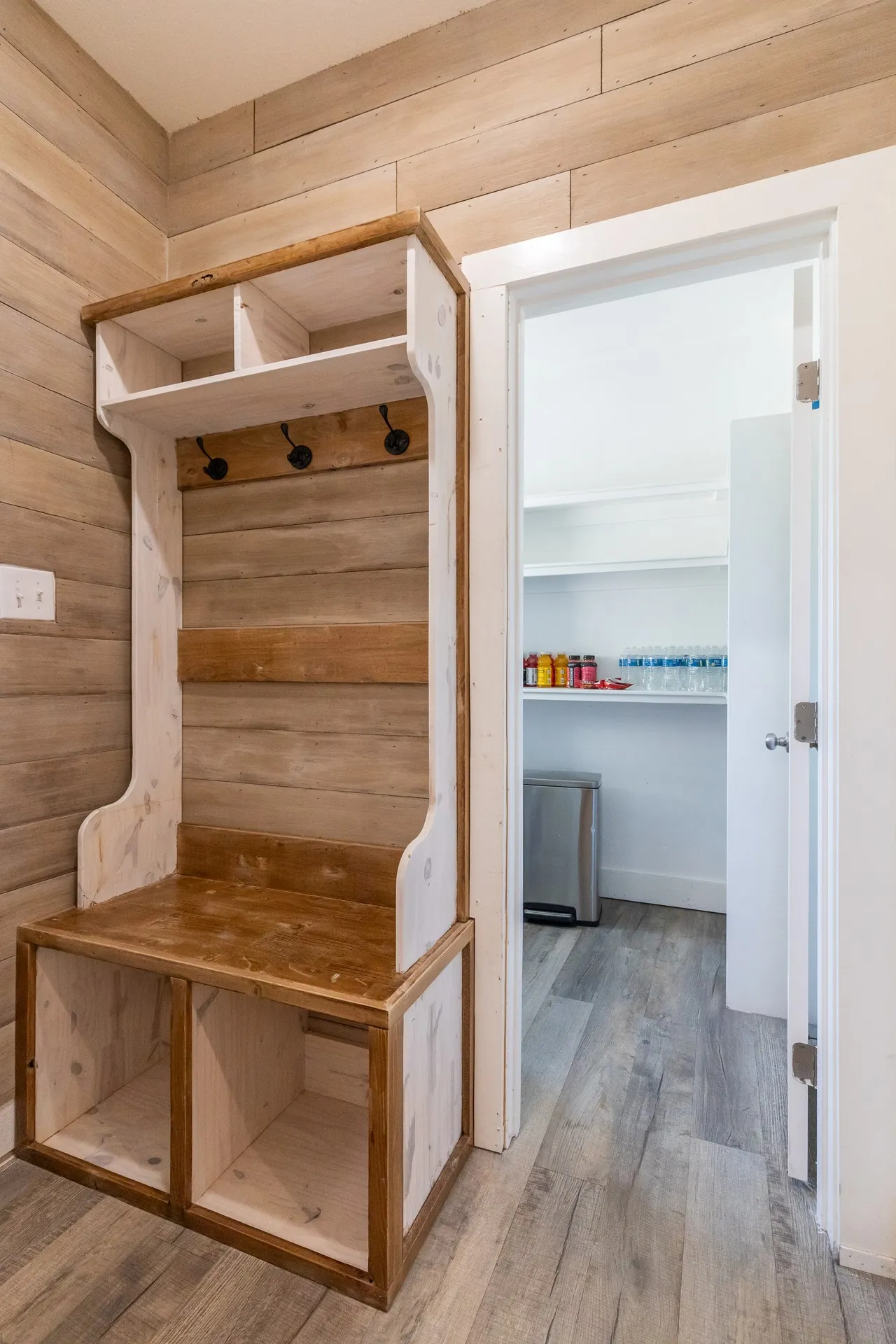 Built-in hall tree featuring storage cubbies, bench seating, and upper shelving